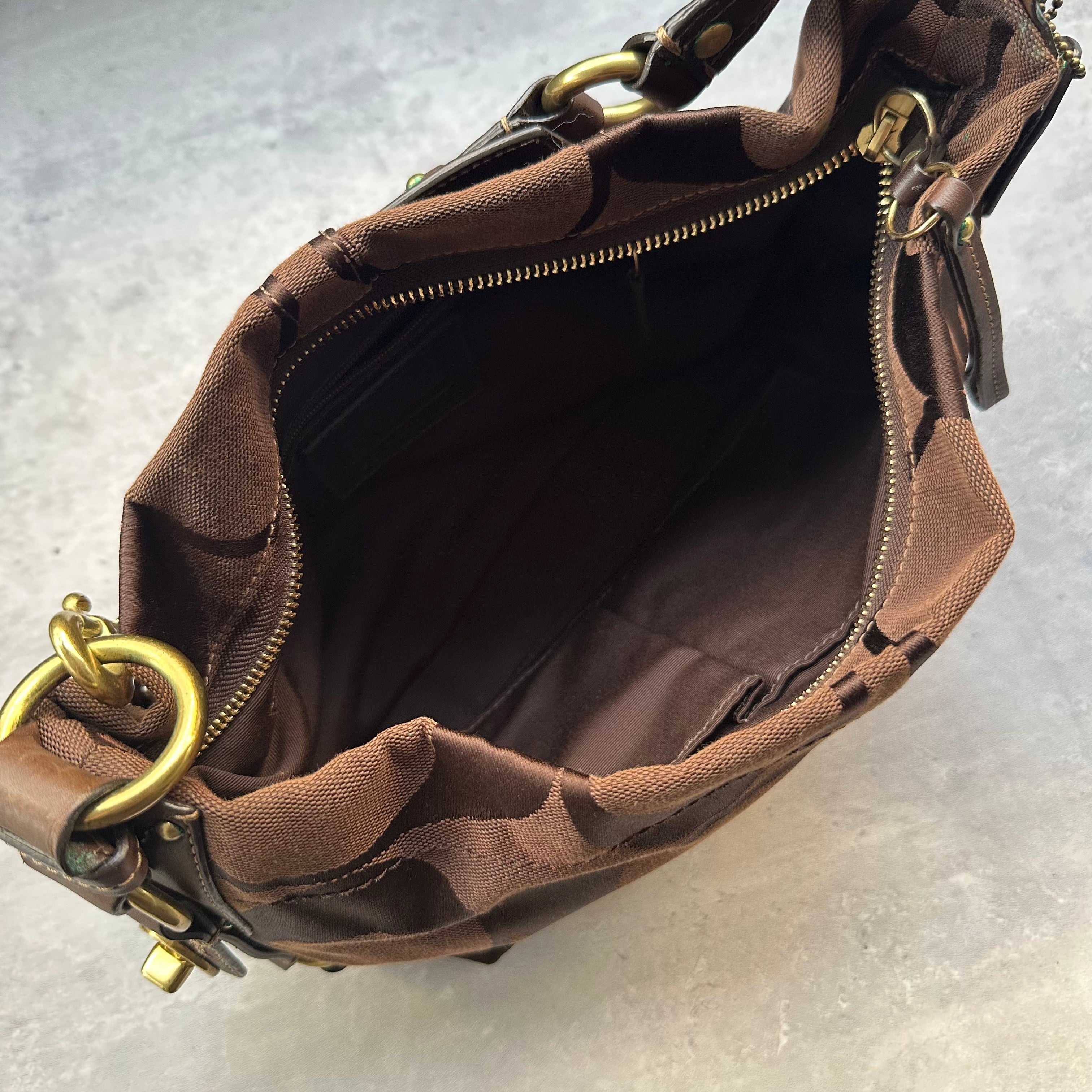 Coach Signature Canvas Hobo Shoulder Bag in brown jacquard fabric, featuring brass hardware, leather trim, and a zip-top closure.