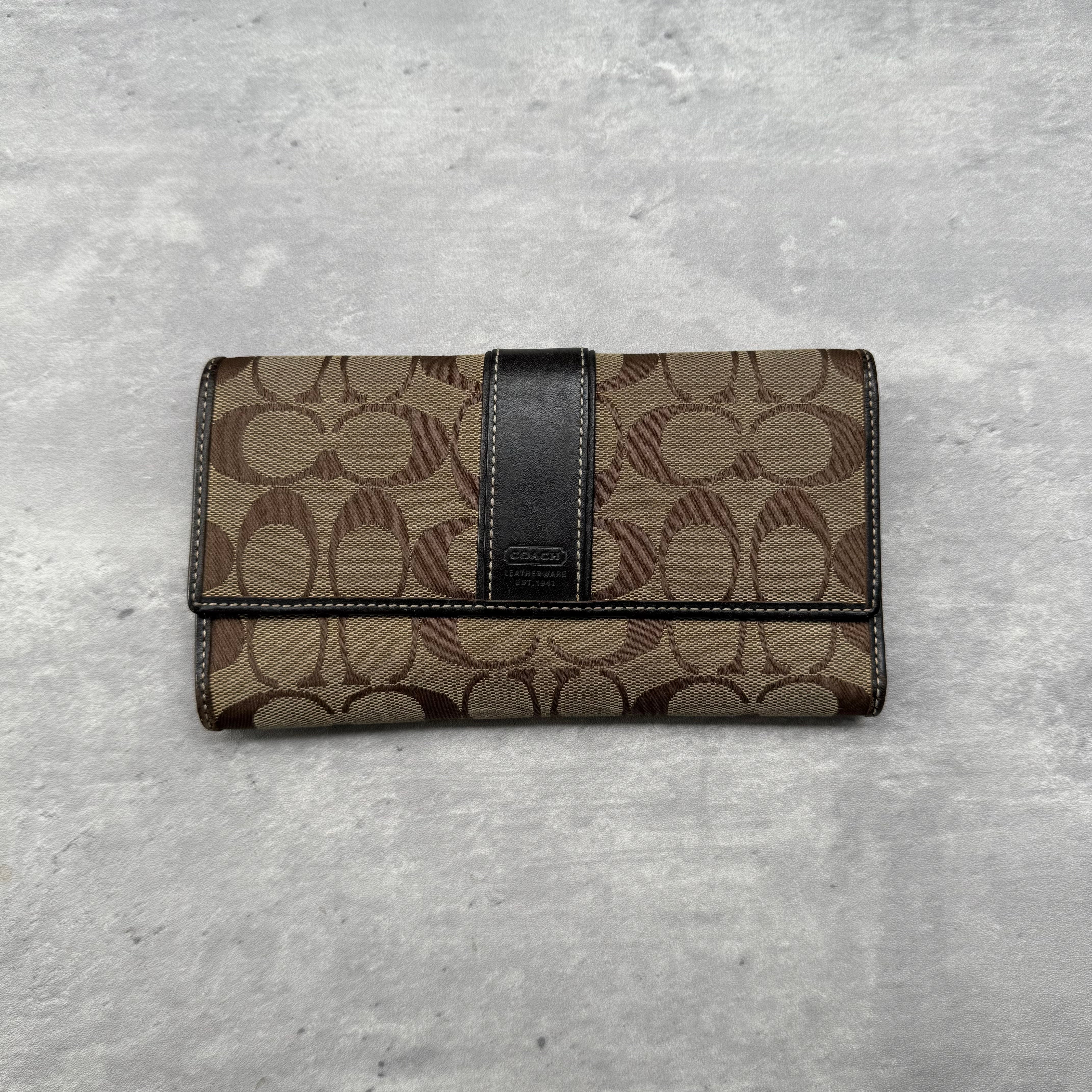 Coach Signature Canvas Long Wallet in beige and brown with black leather strap, featuring card slots, ID window, and zippered compartment.