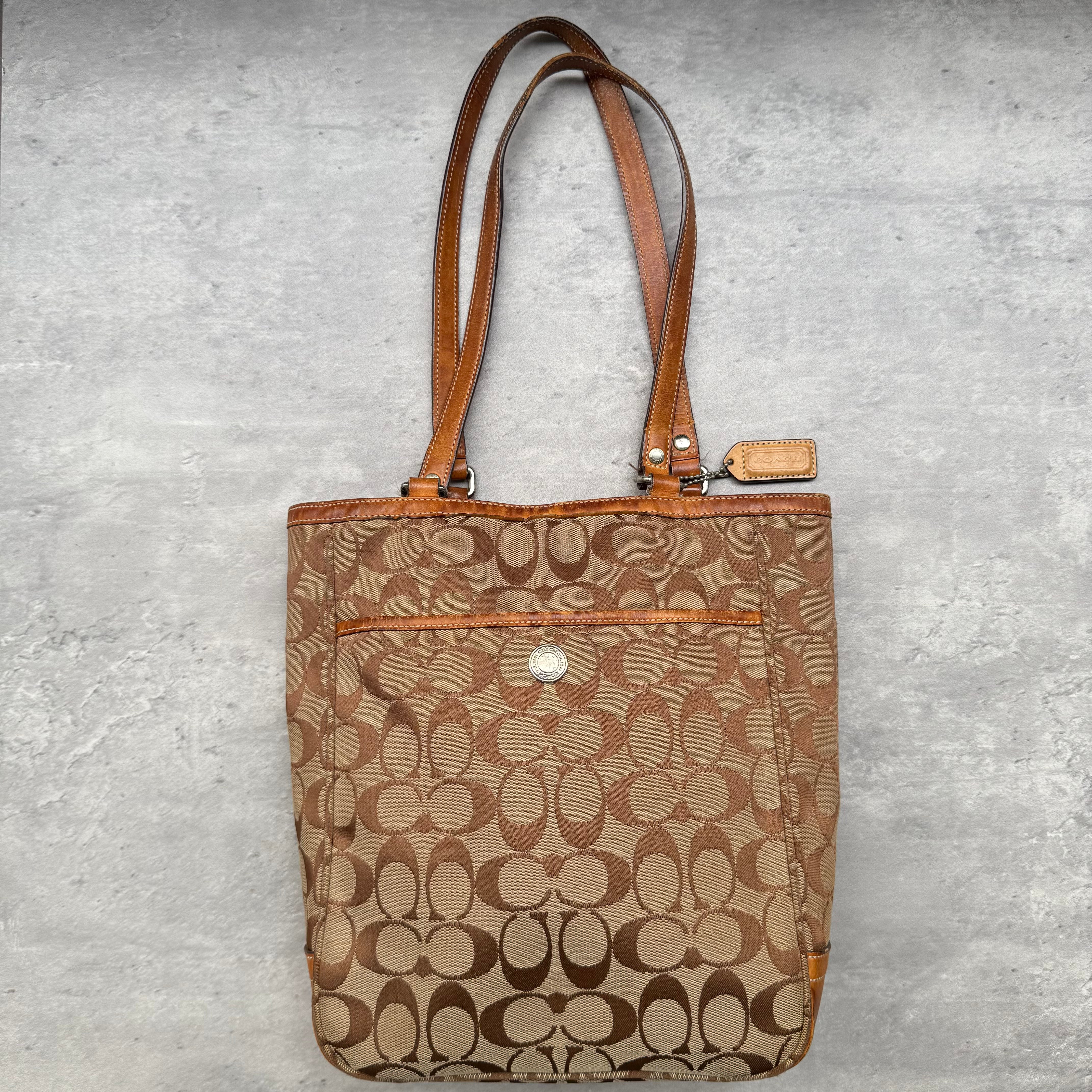 Coach Signature Canvas Tote Bag in beige and tan with leather trims, silver-tone hardware, and spacious interior.
