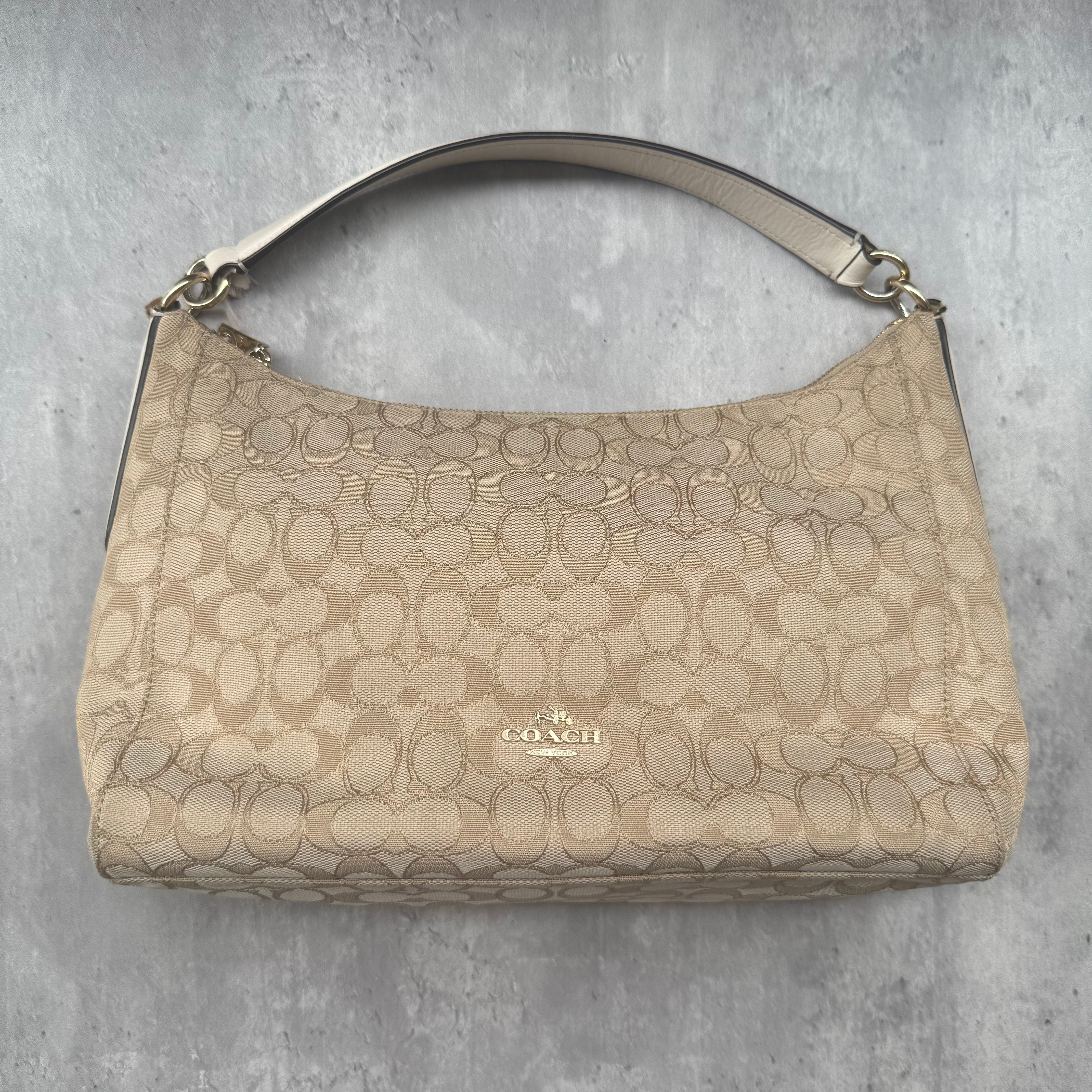 Coach Signature Celeste Hobo Shoulder Bag in beige and white jacquard canvas with gold-tone hardware and zip closure.