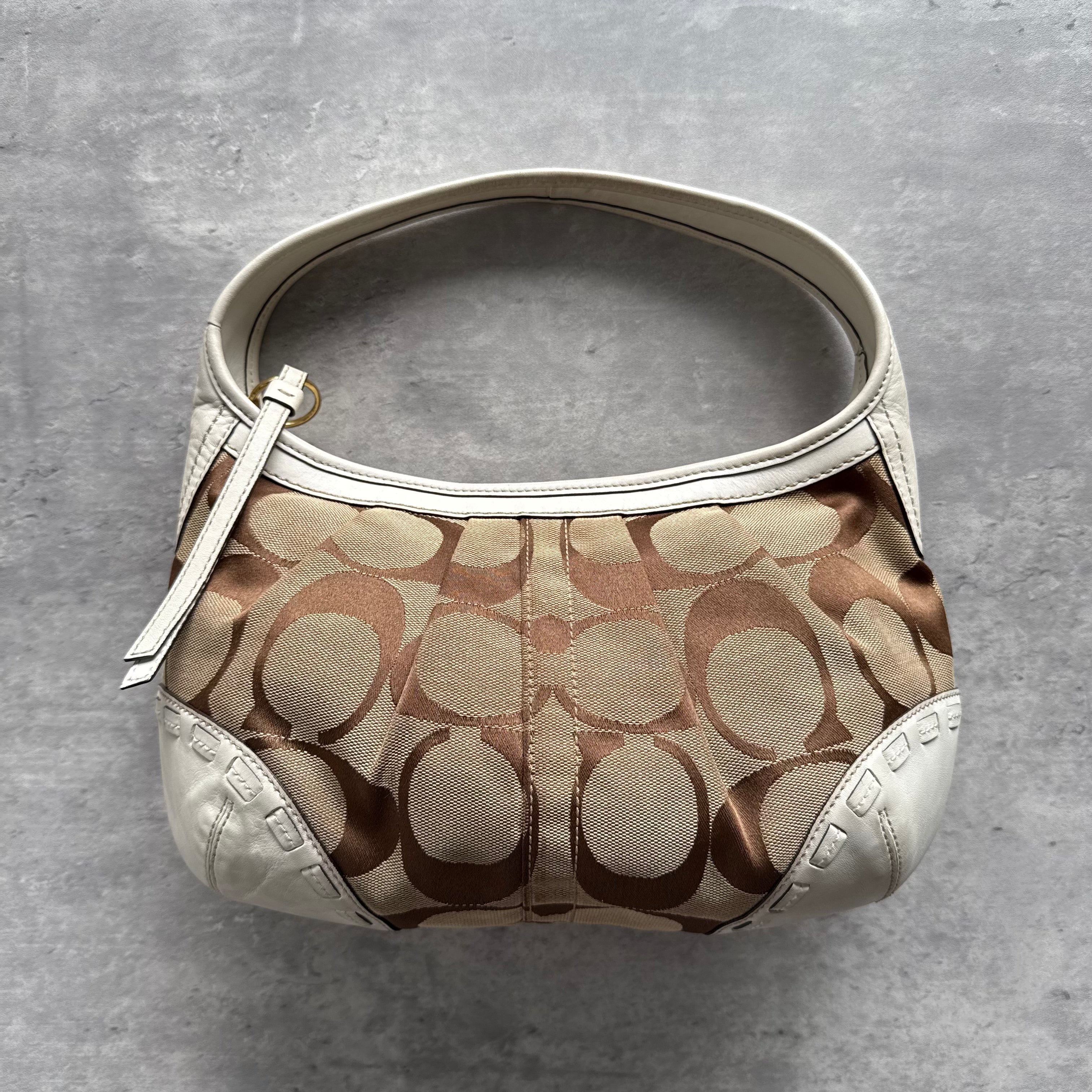 Coach Signature Ergo Shoulder Bag in beige and white, crafted from jacquard canvas with leather trim and silver-tone hardware.