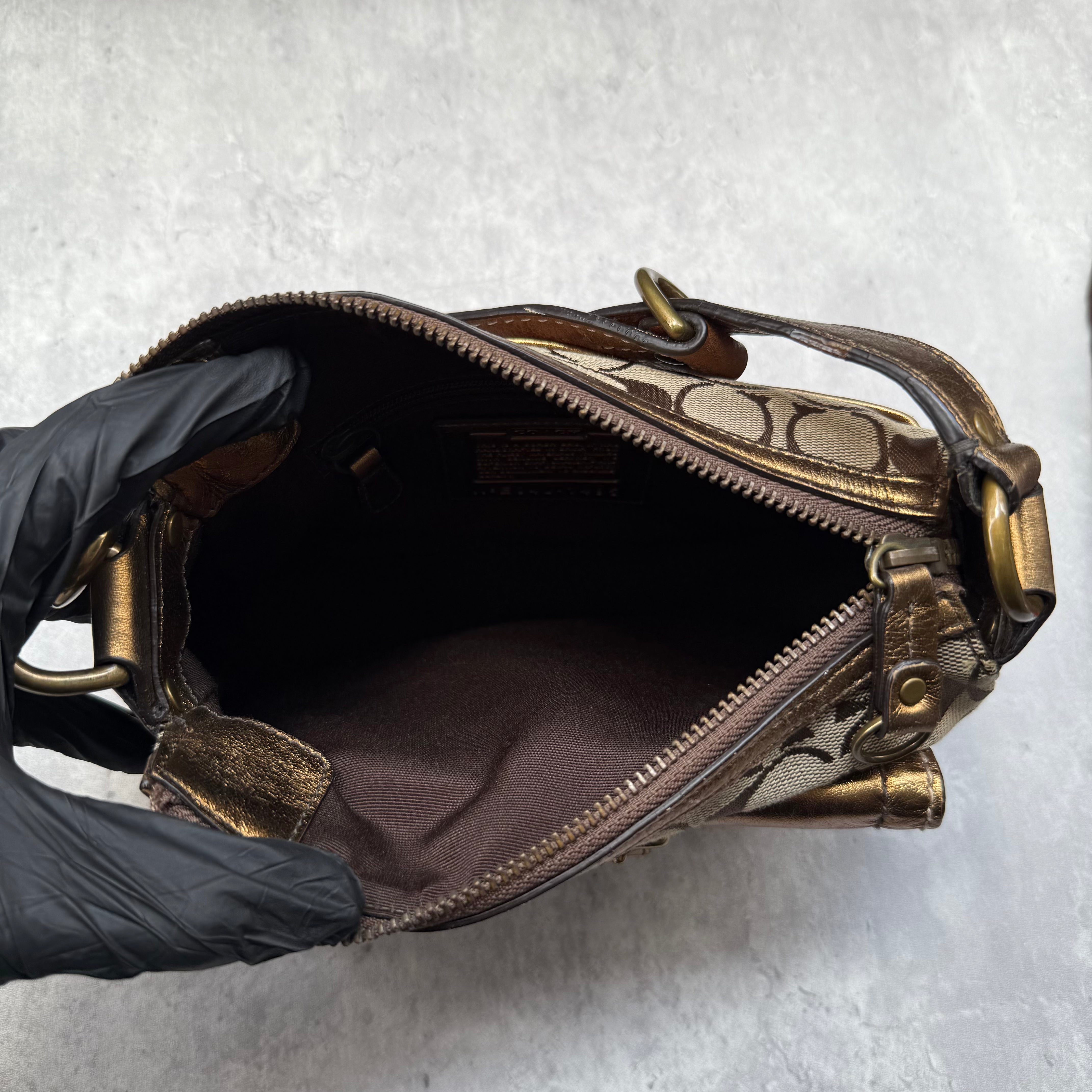 Coach Signature Shoulder Bag in beige canvas with gold metallic front buckle pocket, brown suede accents, and short strap.