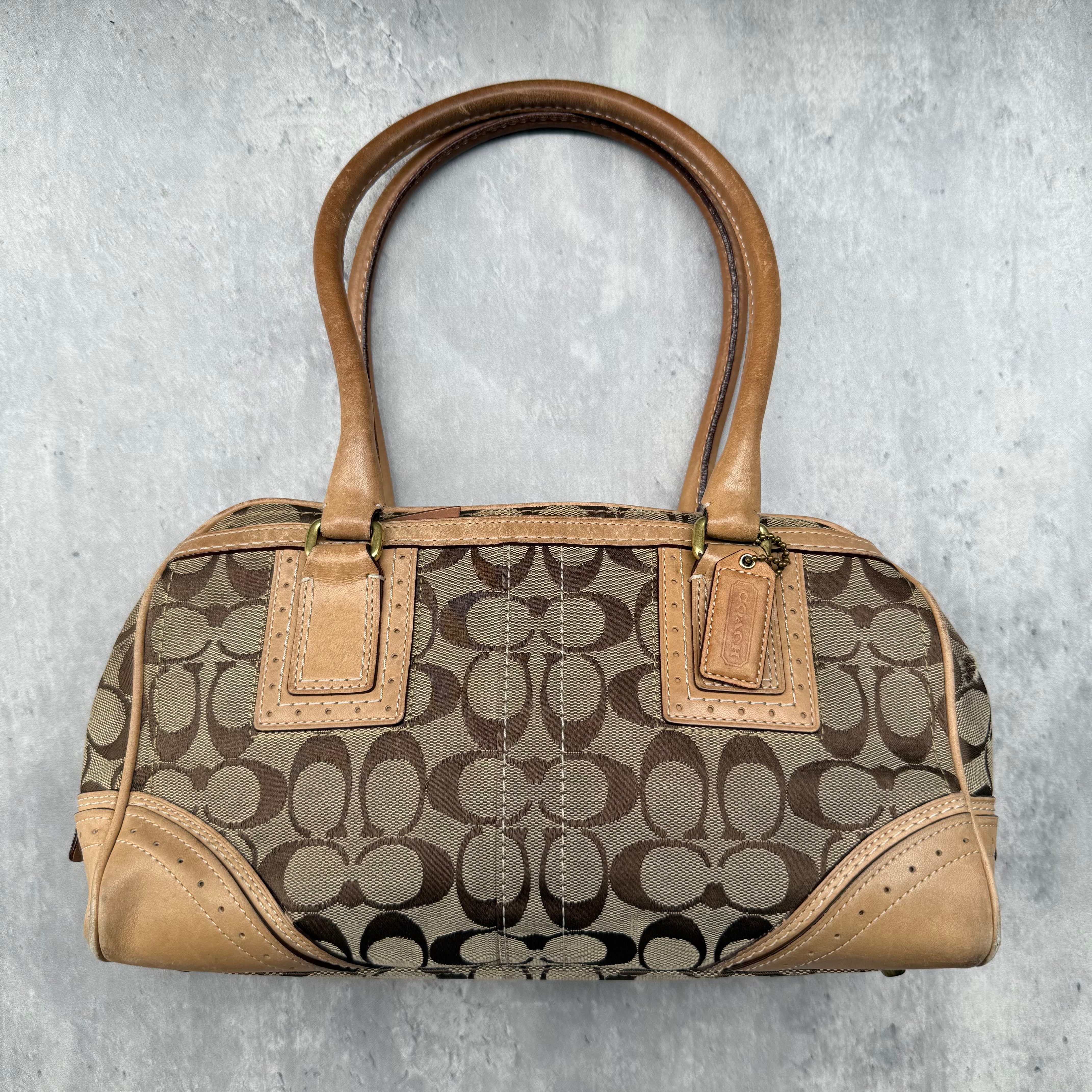Coach Signature Mini Boston Handbag in beige and tan monogram canvas with leather trim and brass-tone hardware.