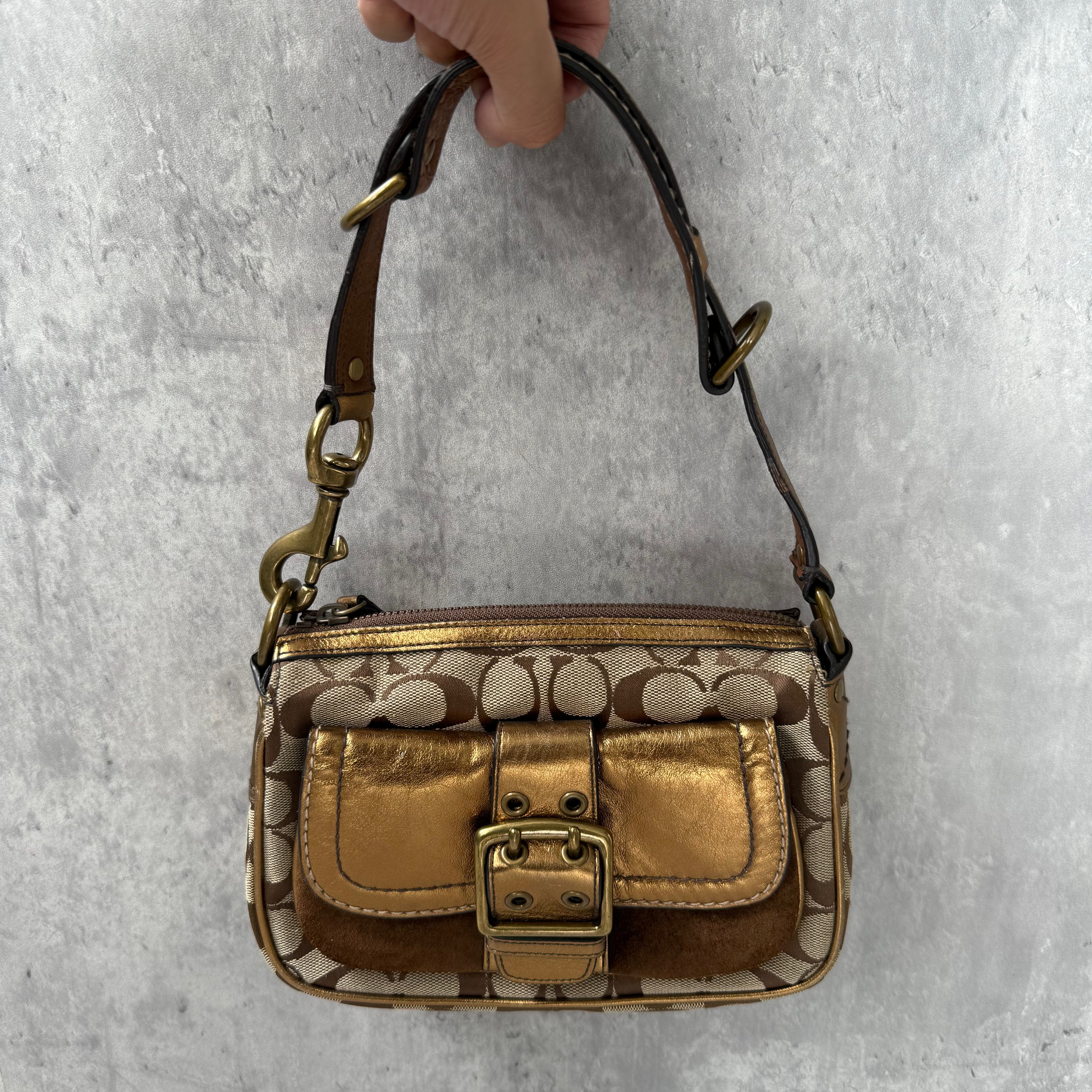Coach Signature Shoulder Bag in beige canvas with gold metallic front buckle pocket, brown suede accents, and short strap.