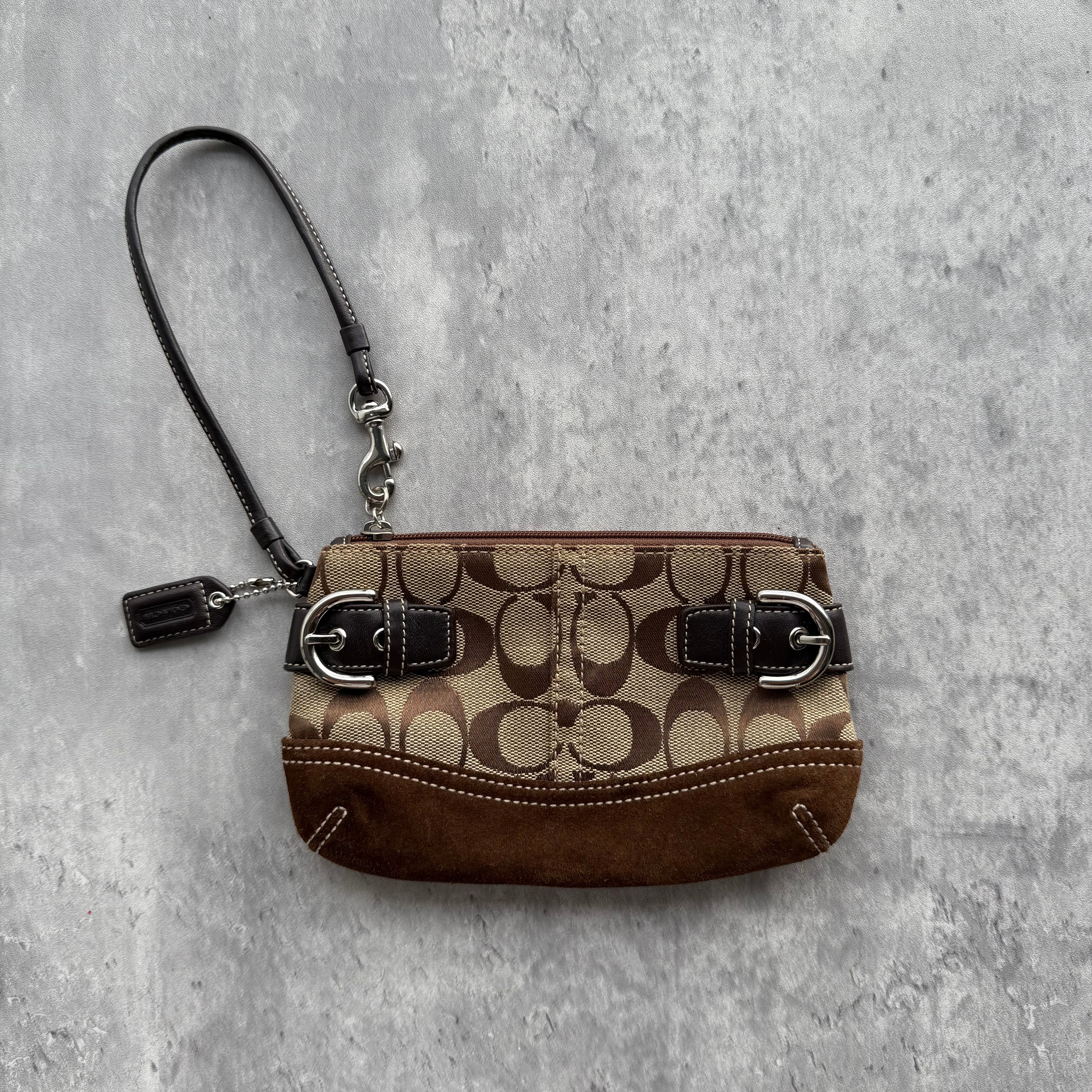 Coach Signature Soho Buckle Wristlet Brown with jacquard canvas, suede trim, silver-tone buckle accents, and detachable wrist strap.