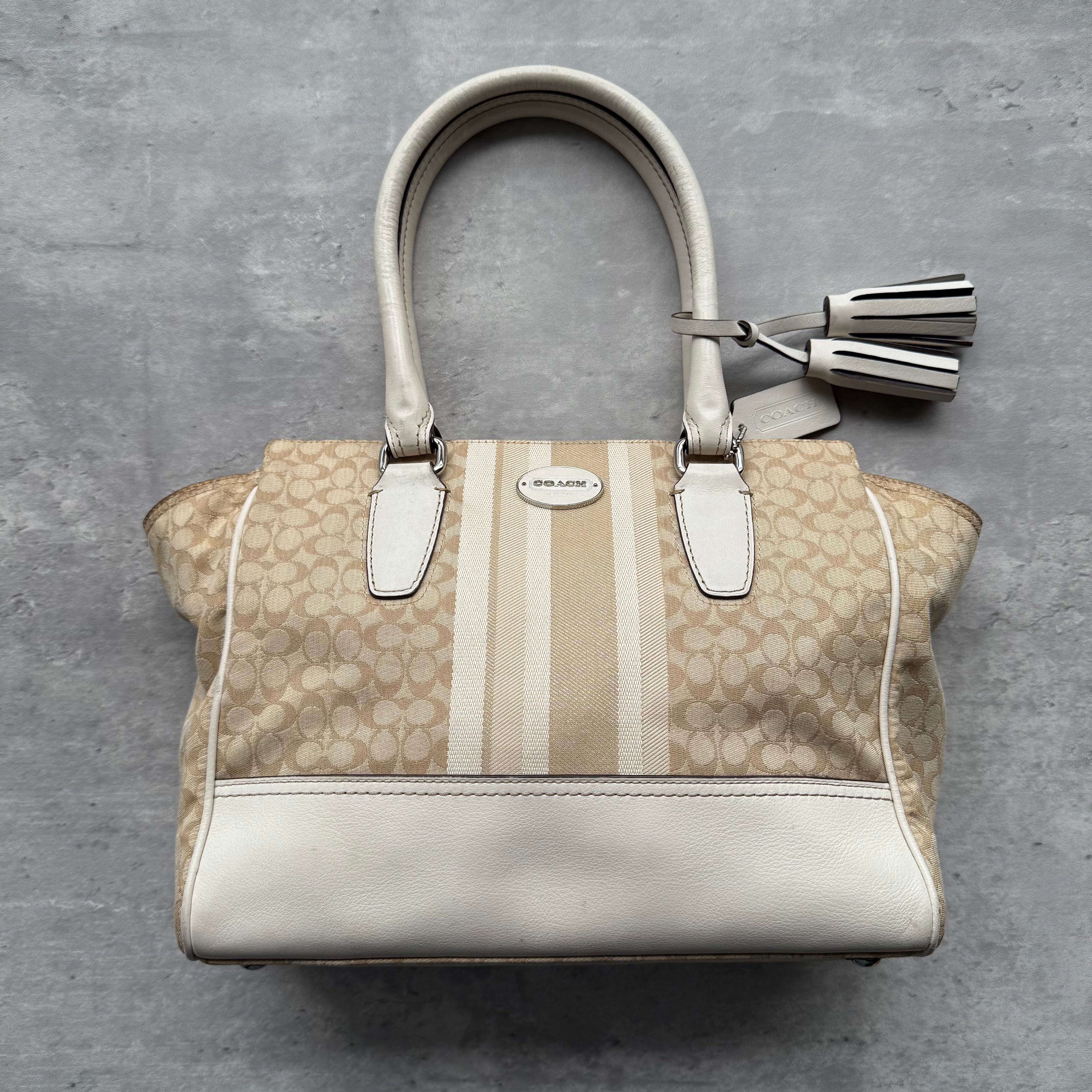 Coach Signature Stripe Candace Carryall Handbag in beige jacquard canvas with white leather trim, featuring dual handles, tassel charm, and spacious compartments.