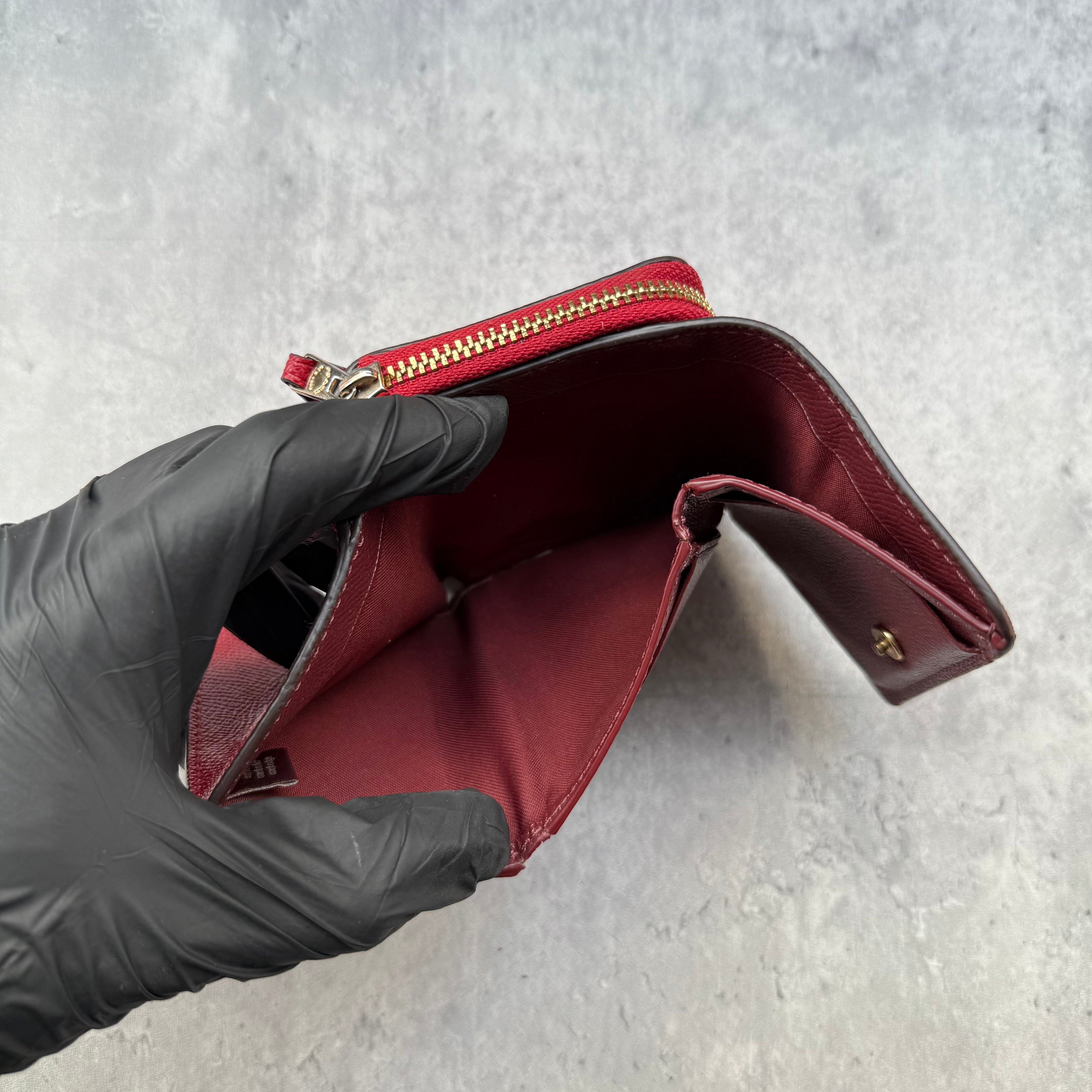 Coach Small Trifold Wallet in Red Pebbled Leather with gold-tone logo and zip coin pocket.