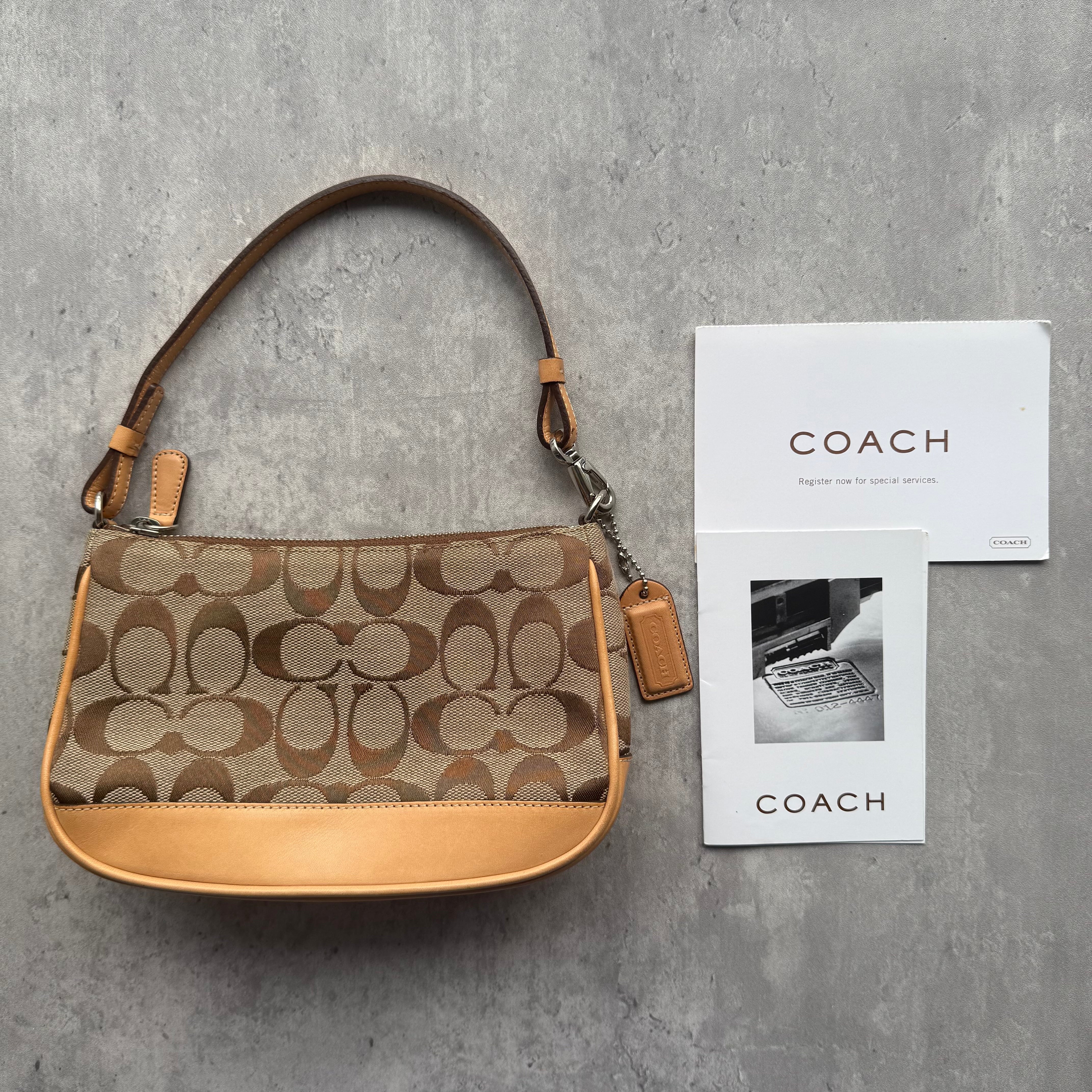 Coach Y2K Demi Shoulder Bag in tan monogram jacquard with leather trim, silver-tone hardware, and vibrant orange interior lining.