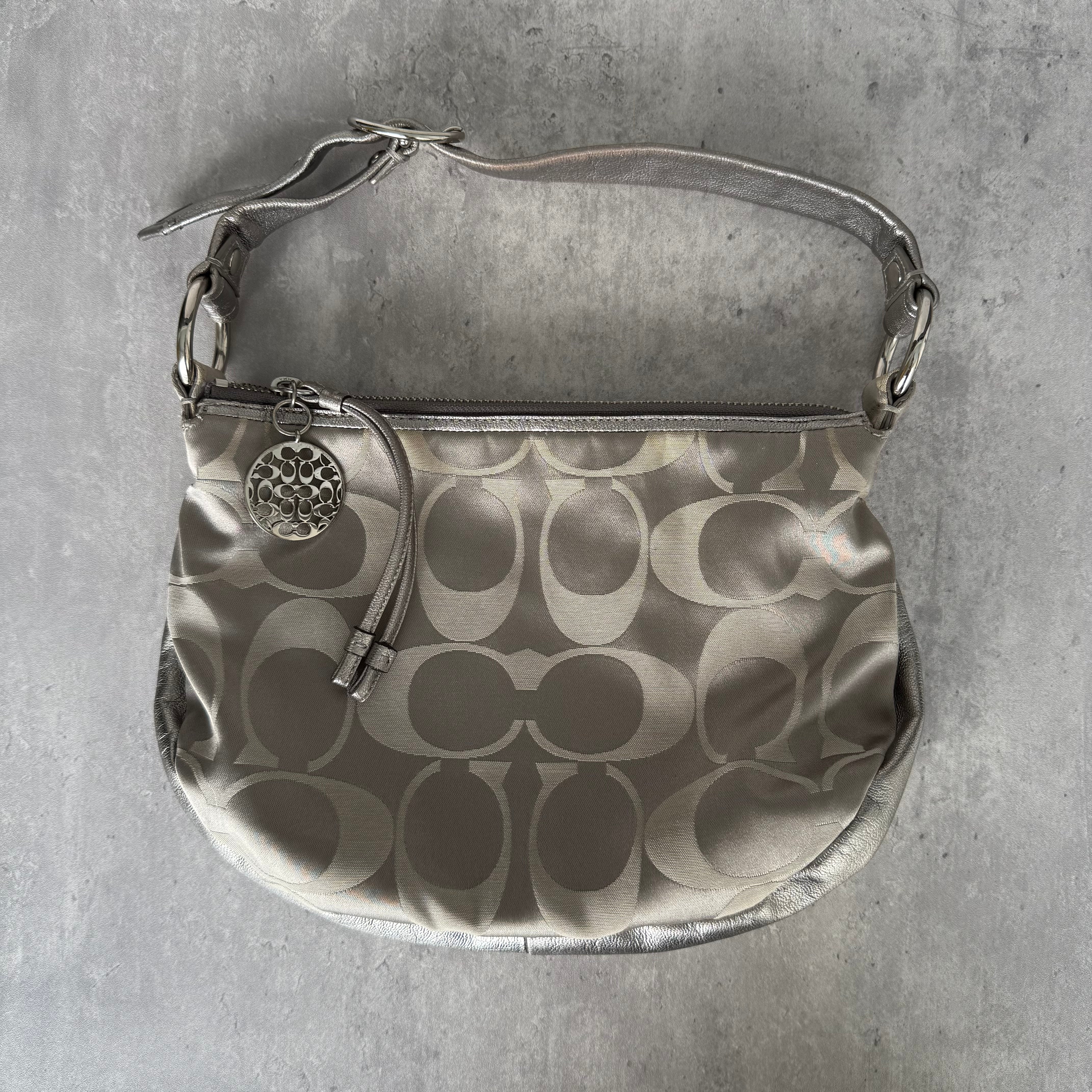 Coach Y2K Signature Hobo Shoulder Bag Silver, with jacquard satin body, silver leather trim, top zip, and circular Coach charm.