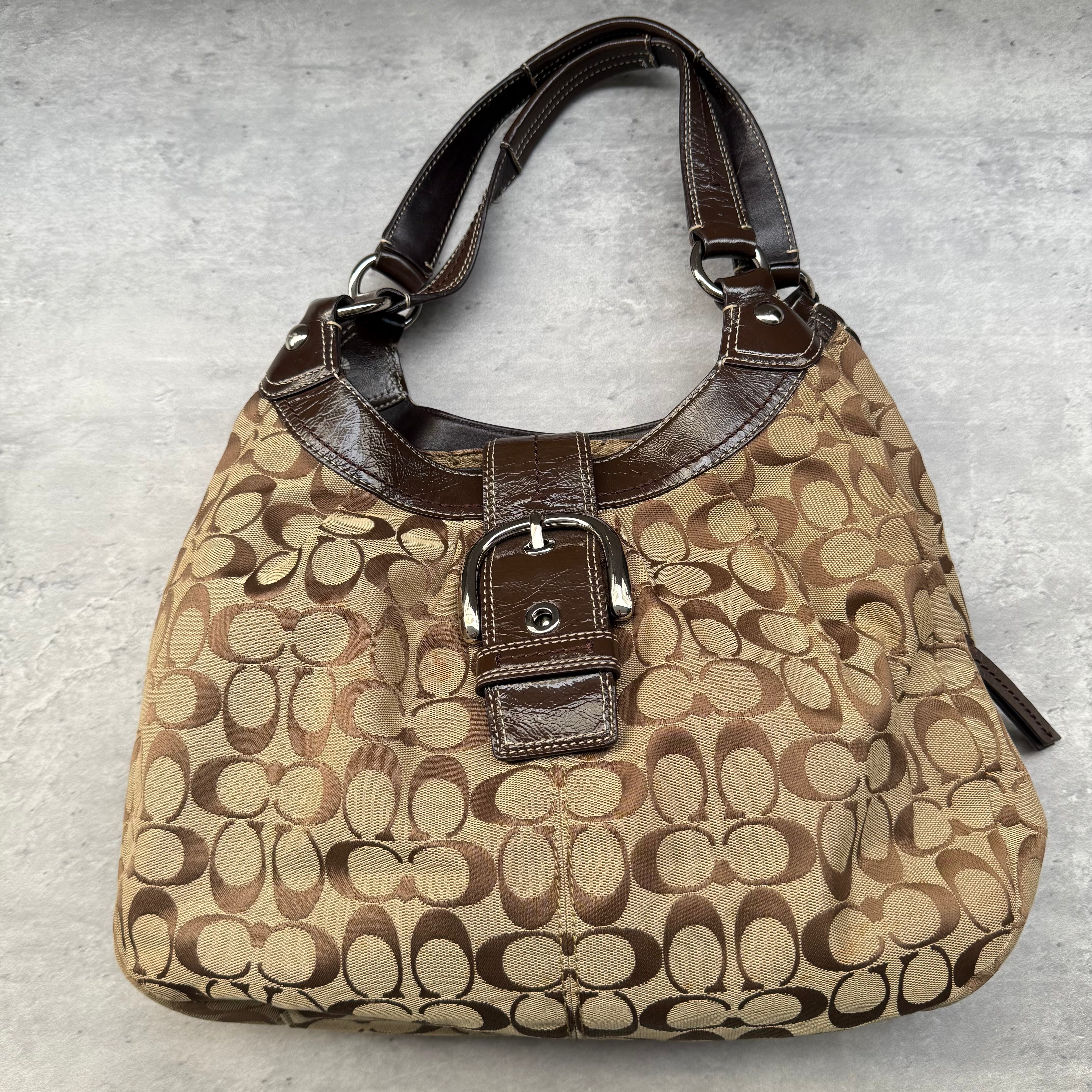 Coach Y2K Soho Hobo Buckle Shoulder Bag in brown and beige monogram canvas with leather trim and silver-tone buckle.