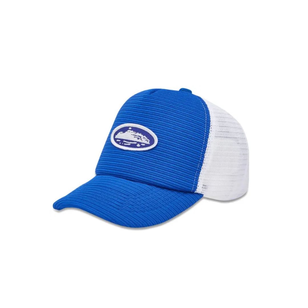 Corteiz Short Peak Trucker Hat in royal blue, featuring ribbed front panel and embroidered yacht logo with white mesh back