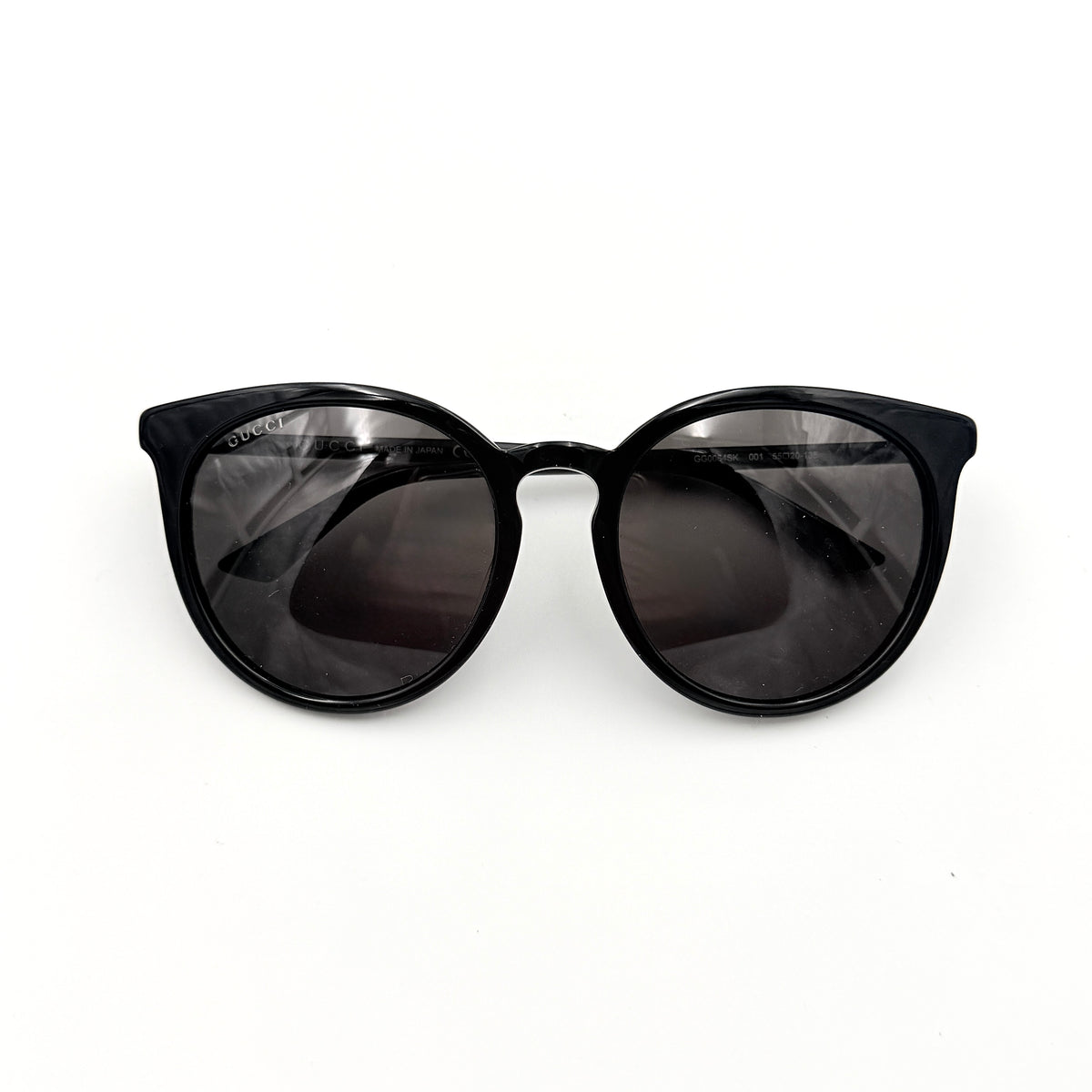 Gucci GG0064SK 001 black round sunglasses with smoky lenses, shown with original burgundy velvet case and pouch.
