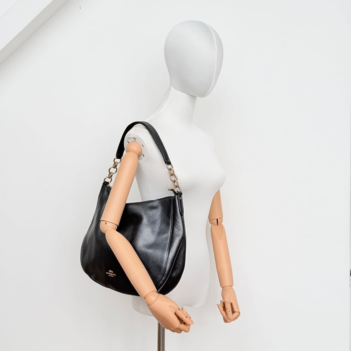 Coach Elle Hobo bag in navy blue pebbled leather with gold hardware and a detachable strap, styled on a white background.