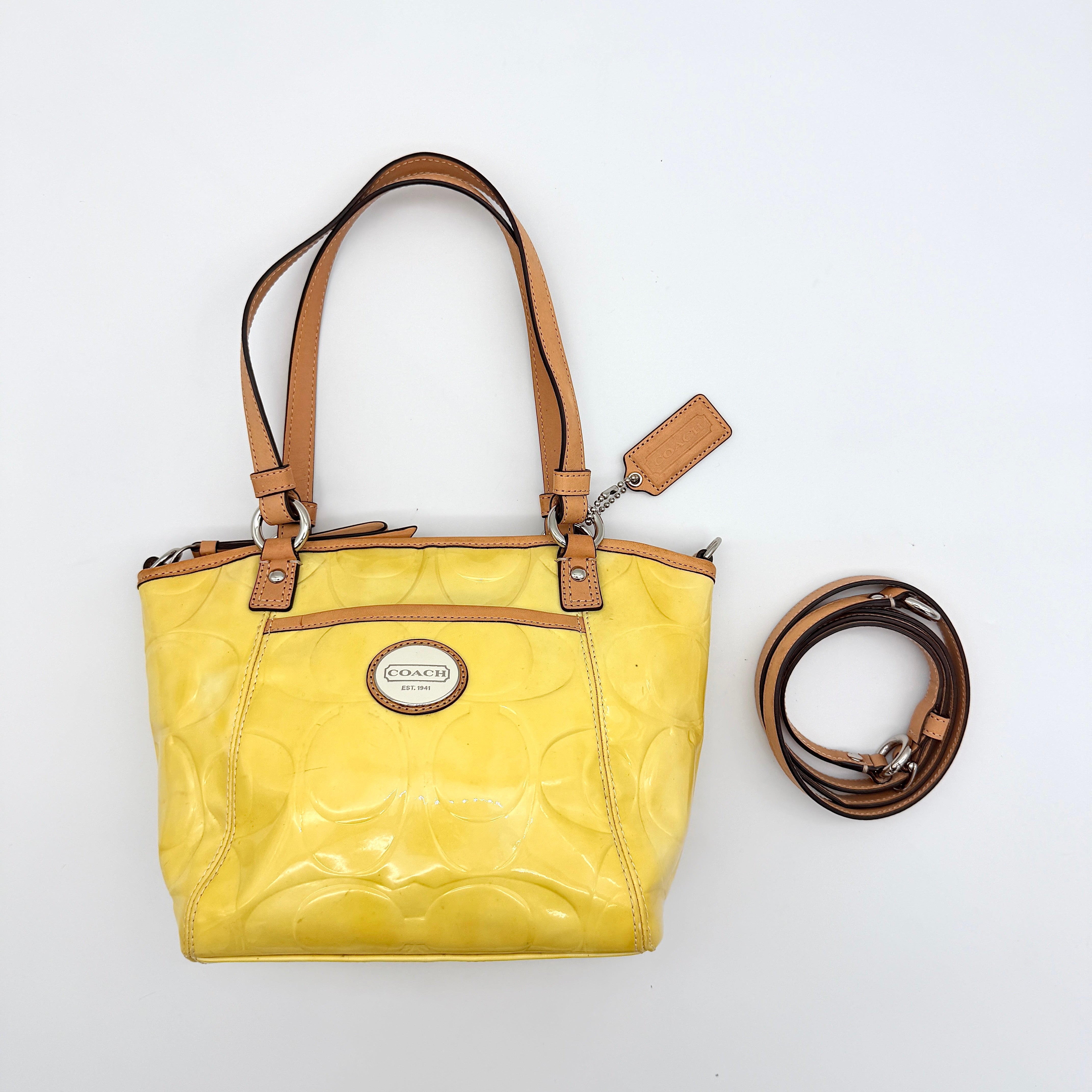 Coach Peyton tote in glossy yellow patent leather with tan handles and detachable strap, shown with blush pink interior.
