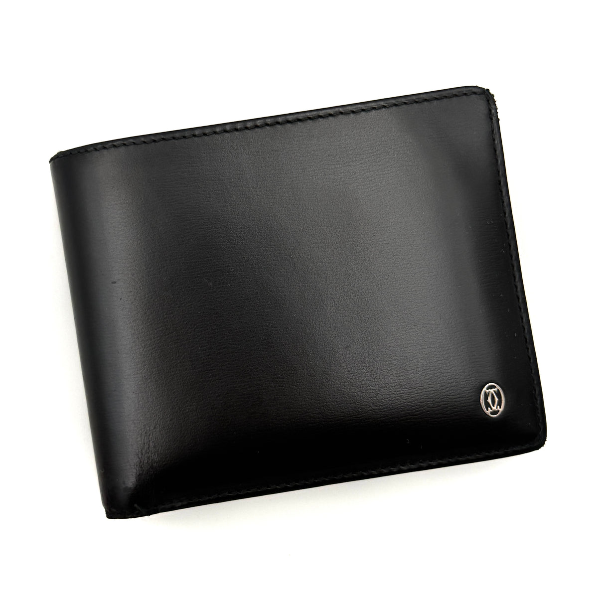 Cartier Must de Cartier black leather bifold wallet, shown with its signature red box and authentication card.