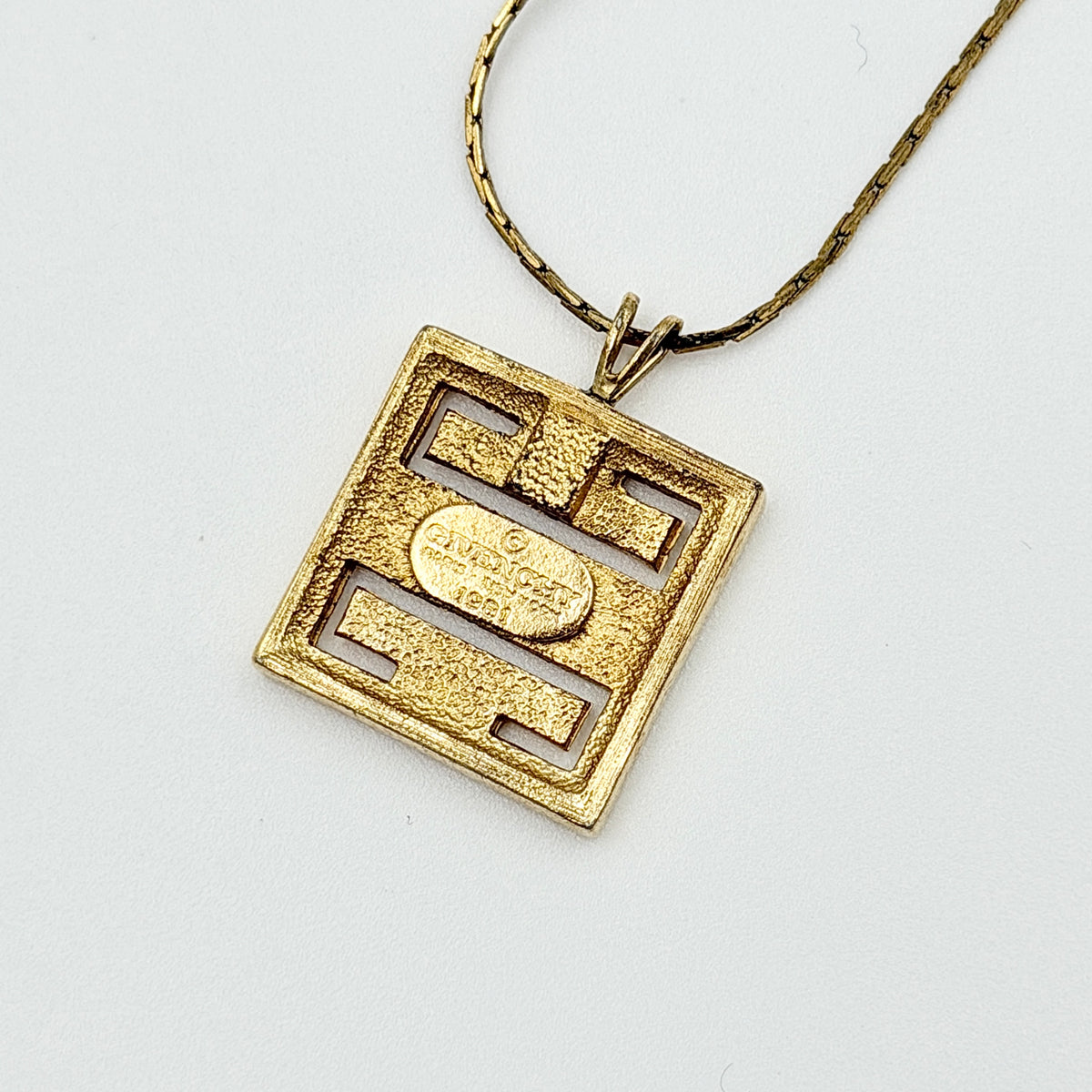 Givenchy 4G Logo Necklace in polished gold-tone metal with a geometric pendant on a fine chain.