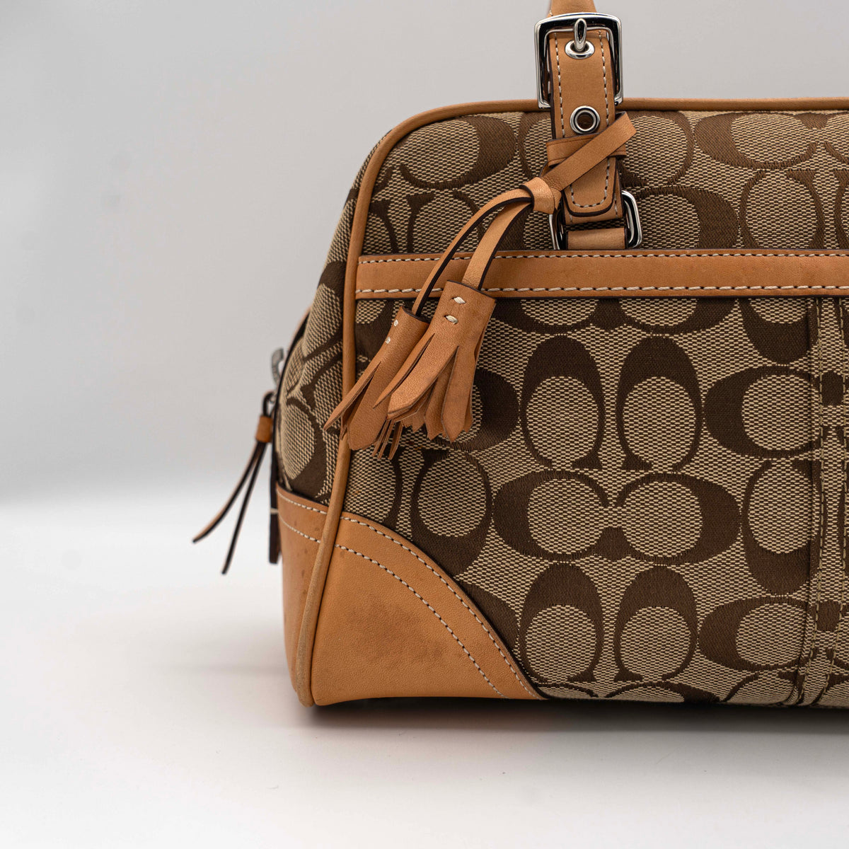 Coach Signature Hampton Satchel Boston Bag in beige and tan canvas with leather trim and silver hardware, styled on a clean background.