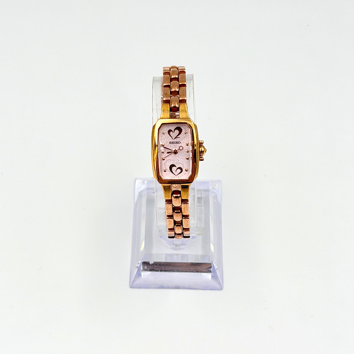 Front view of the Seiko Tisse Nozomi Special Edition watch with a pink heart motif dial and two-tone gold and rose gold bracelet.