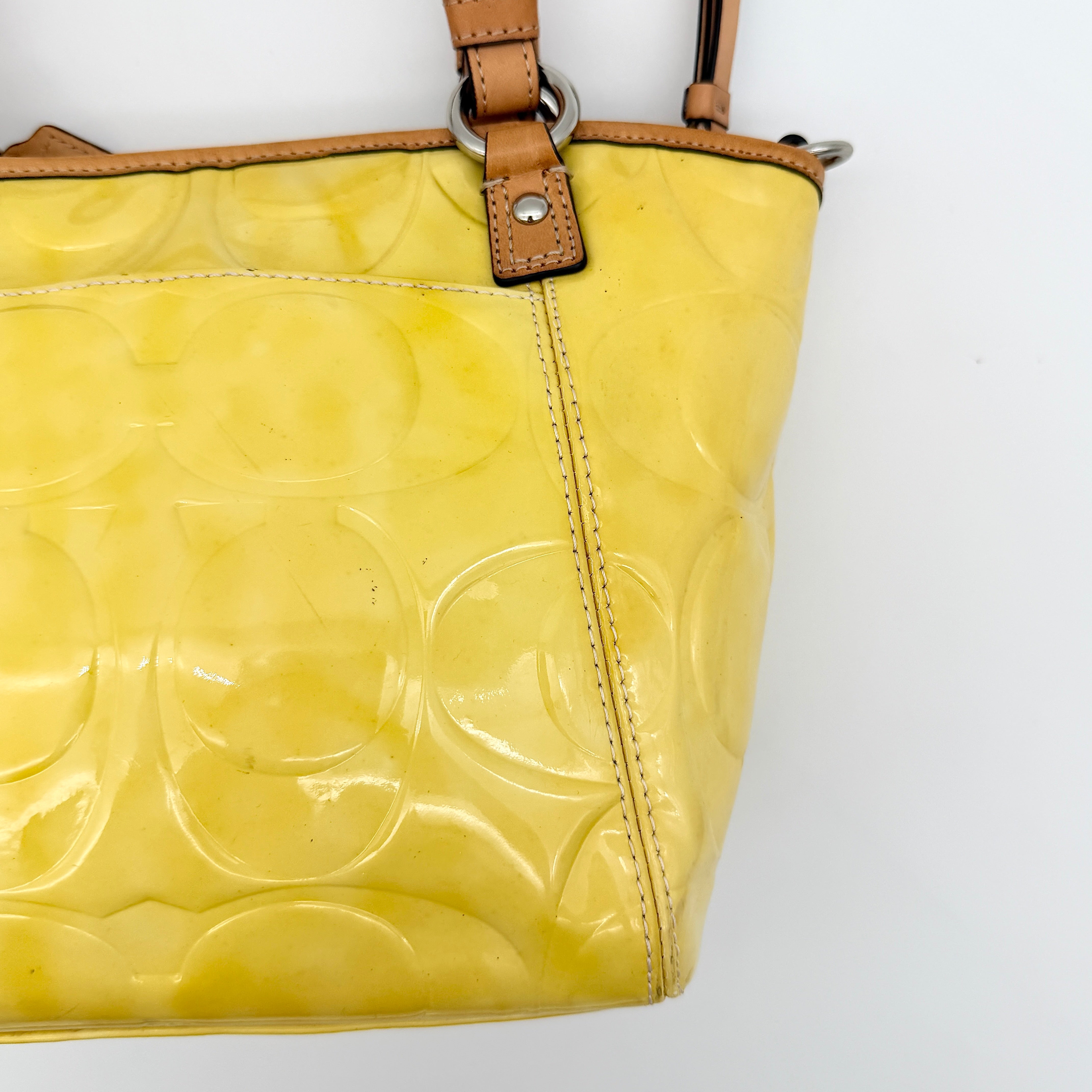 Coach Peyton tote in glossy yellow patent leather with tan handles and detachable strap, shown with blush pink interior.