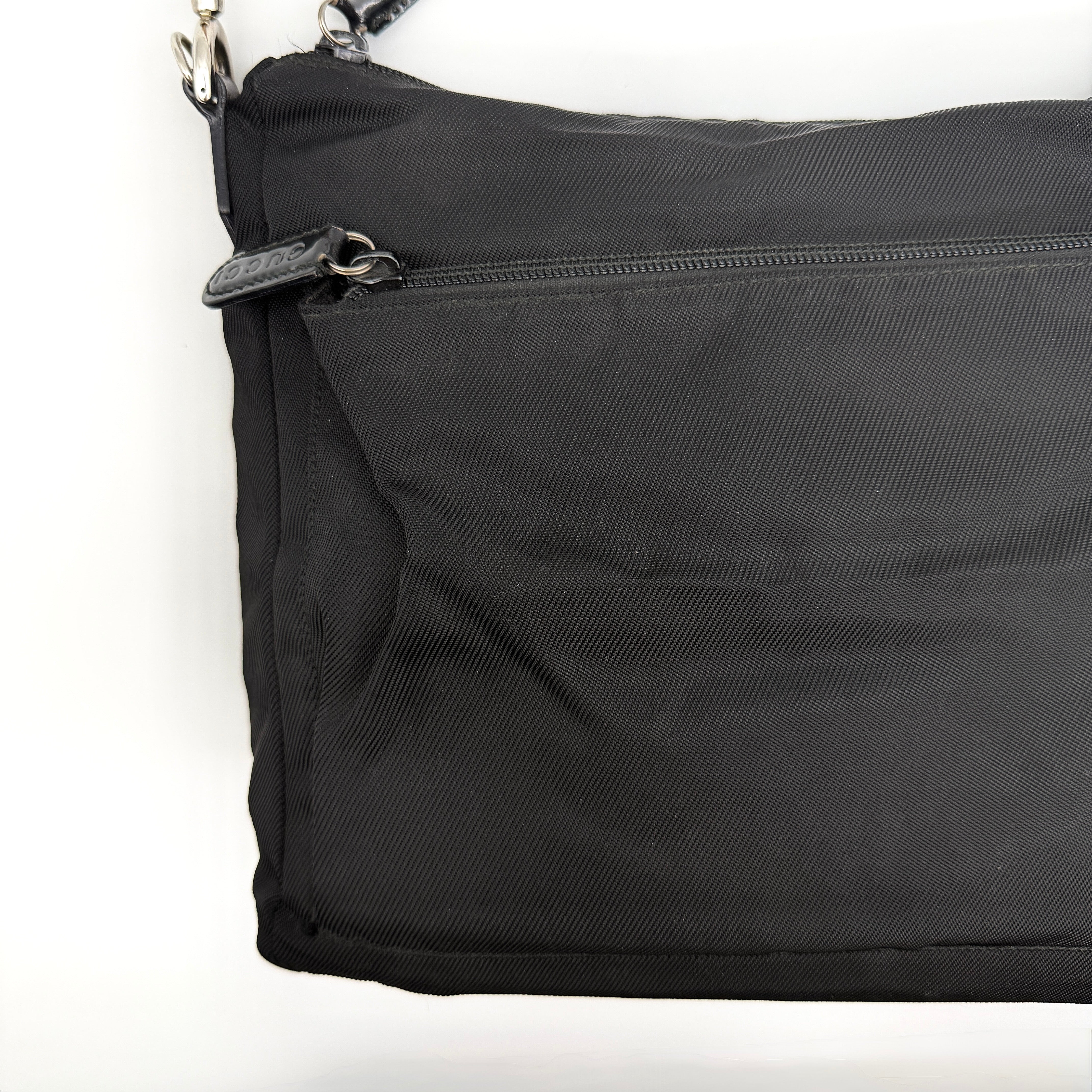 Gucci nylon shoulder bag in black with bamboo handle, shown against a white background.