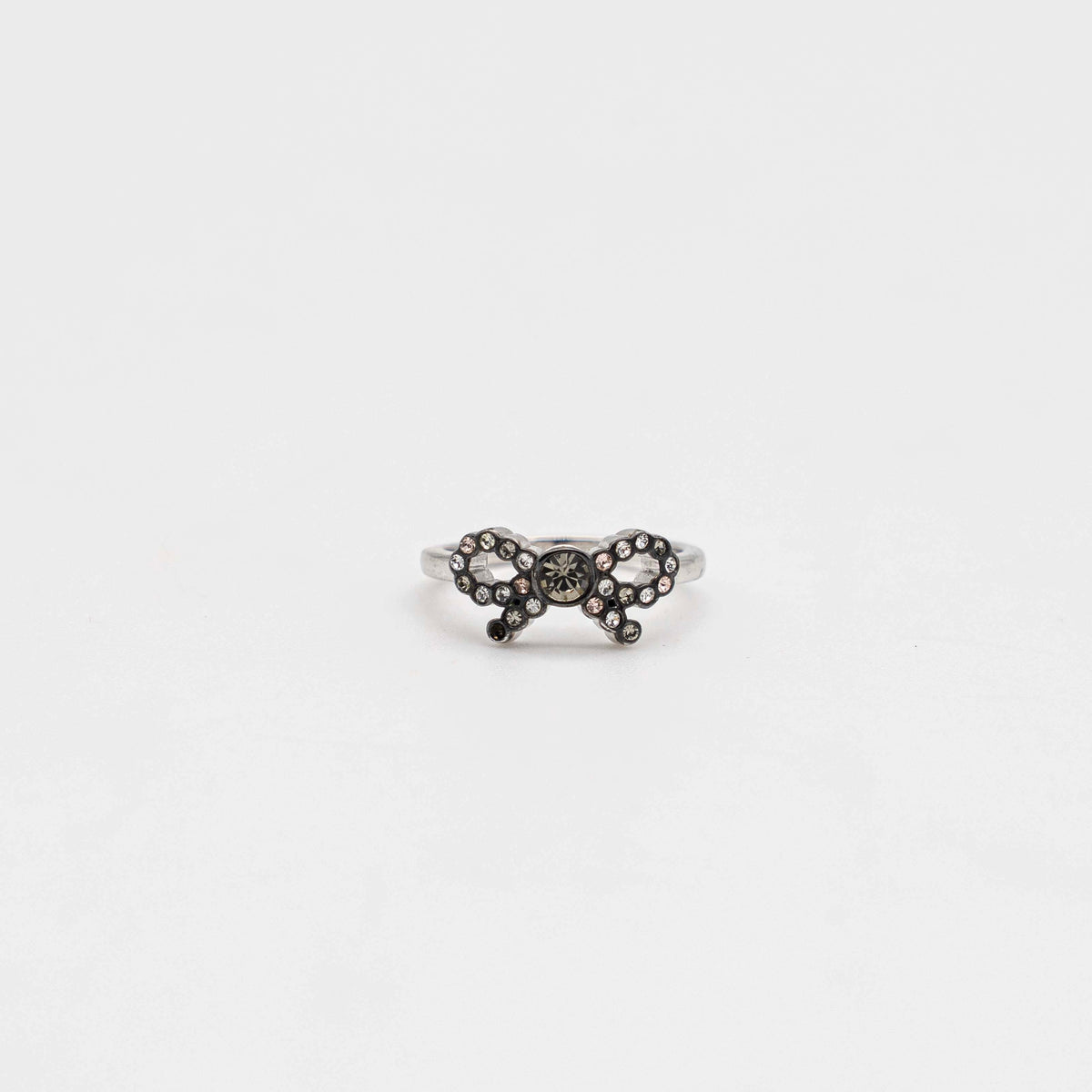 Coach silver ring with a rhinestone-encrusted bow motif, photographed against a white background.