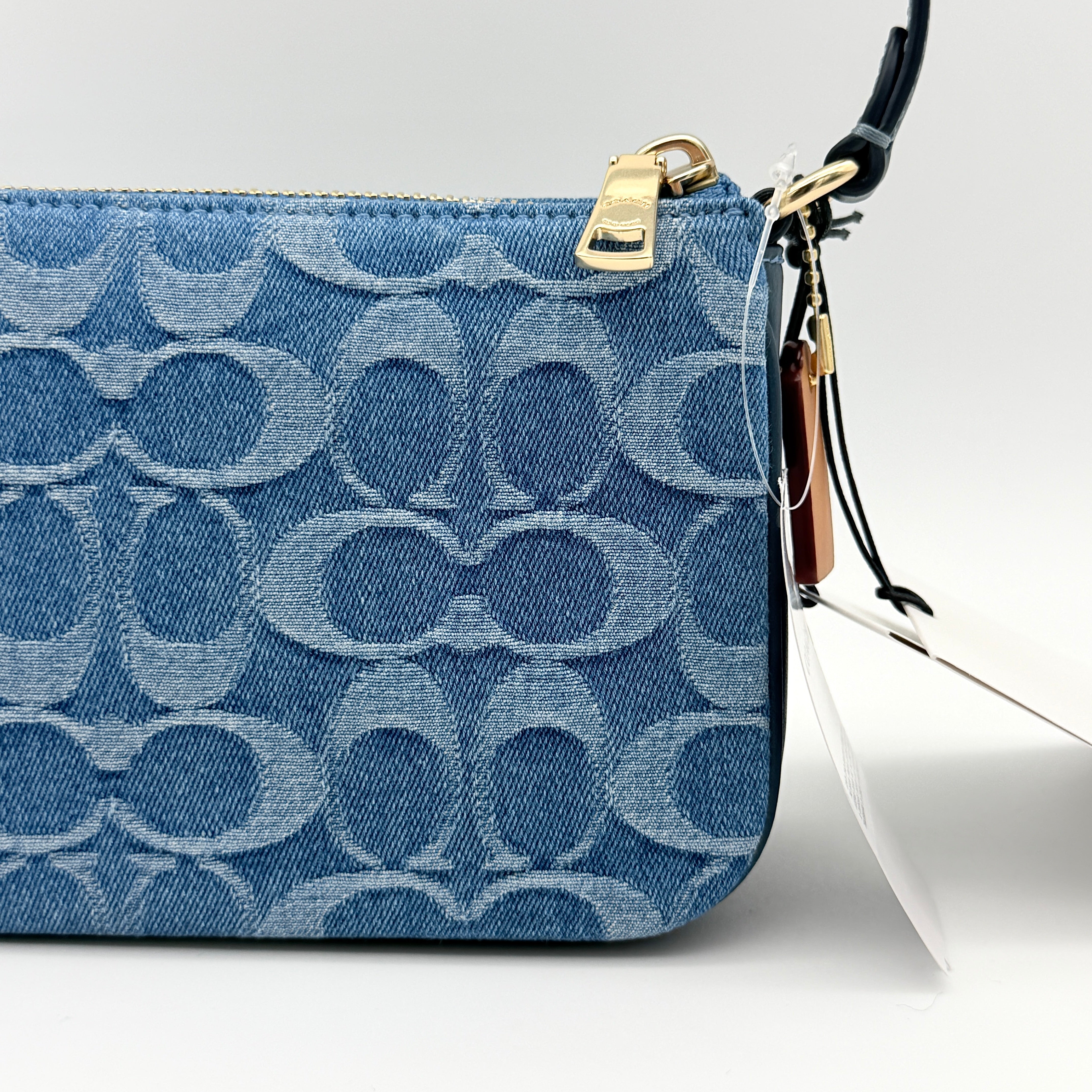 Coach Nolita 19 shoulder bag in blue denim jacquard with monogram print and gold hardware, shown with original packaging.