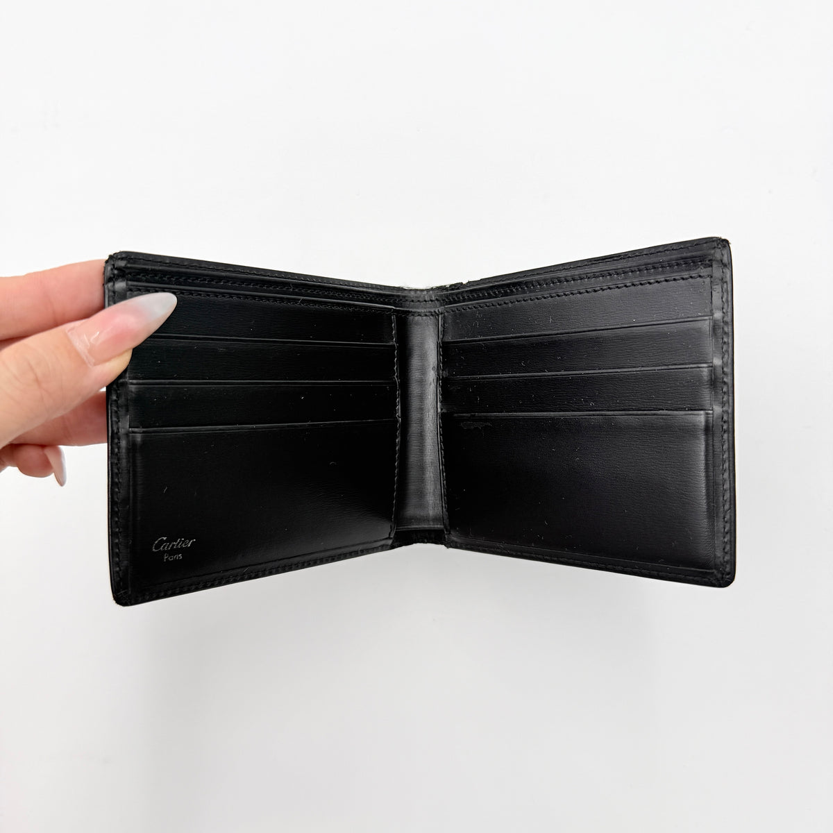 Cartier Must de Cartier black leather bifold wallet, shown with its signature red box and authentication card.
