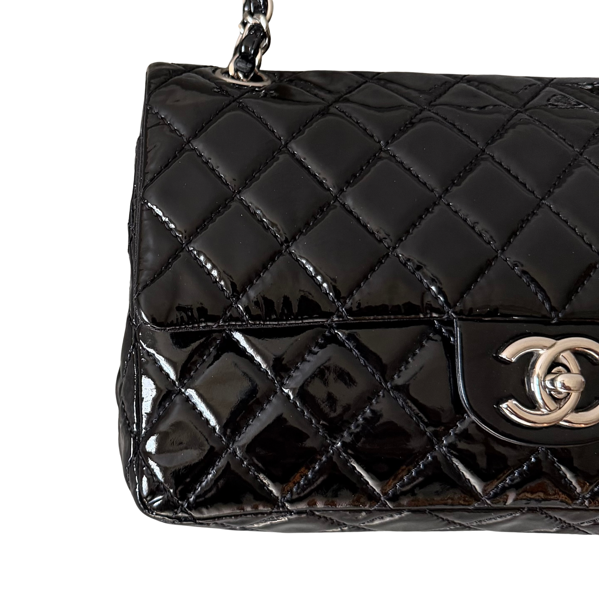 Chanel 25 Matelasse Double Flap bag in glossy black patent leather with silver-tone hardware and quilted finish.