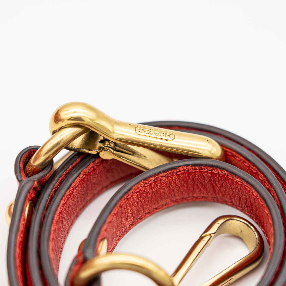 Coach Madison 2Way shoulder bag in rich red quilted texture with gold hardware, top handles, and detachable strap, displayed on a white background.