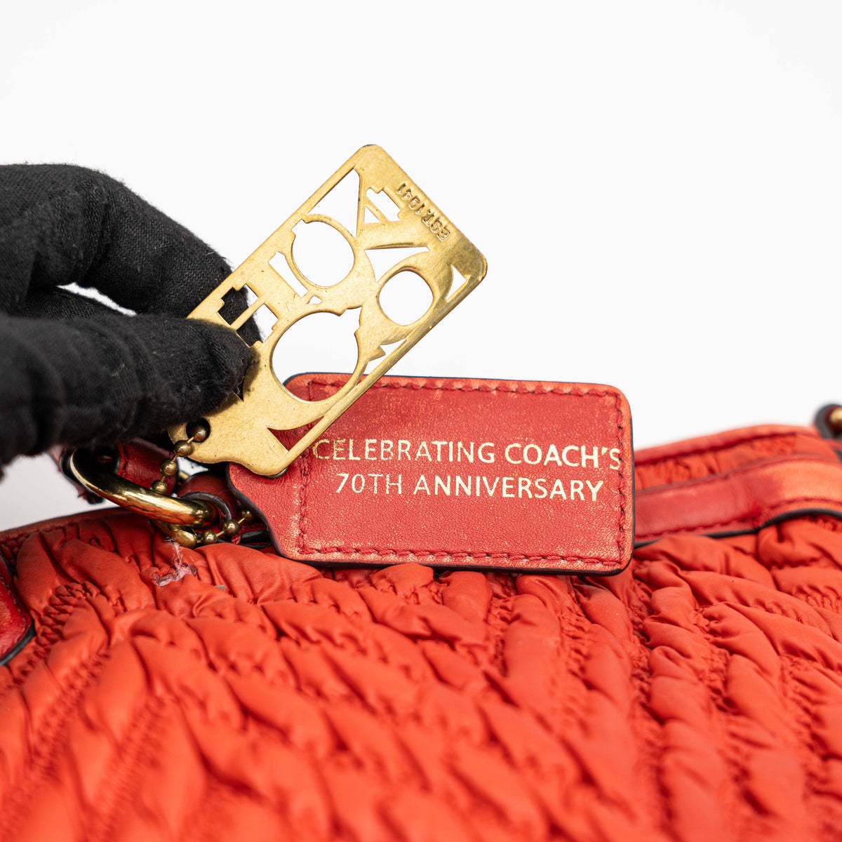 Coach Madison 2Way shoulder bag in rich red quilted texture with gold hardware, top handles, and detachable strap, displayed on a white background.