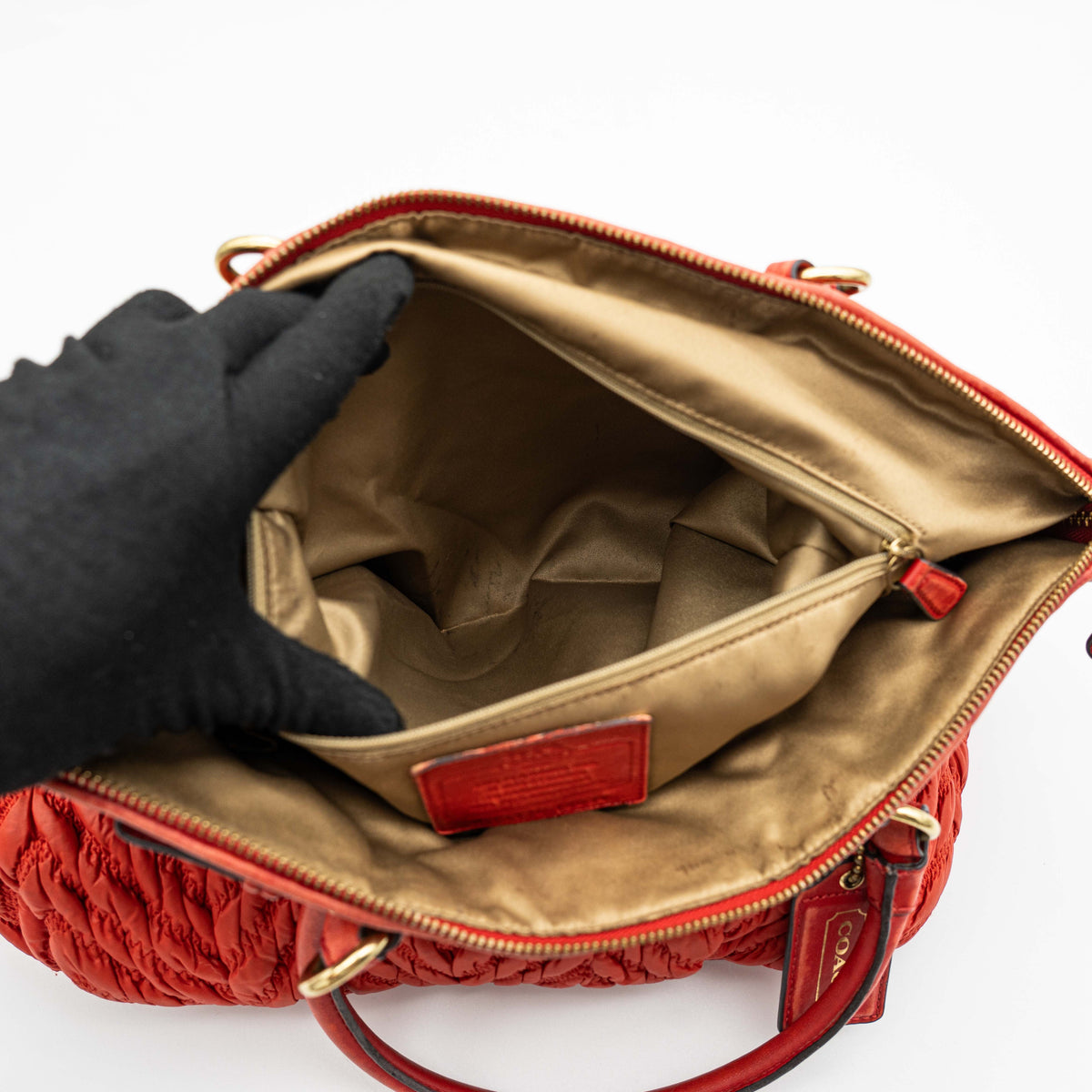 Coach Madison 2Way shoulder bag in rich red quilted texture with gold hardware, top handles, and detachable strap, displayed on a white background.
