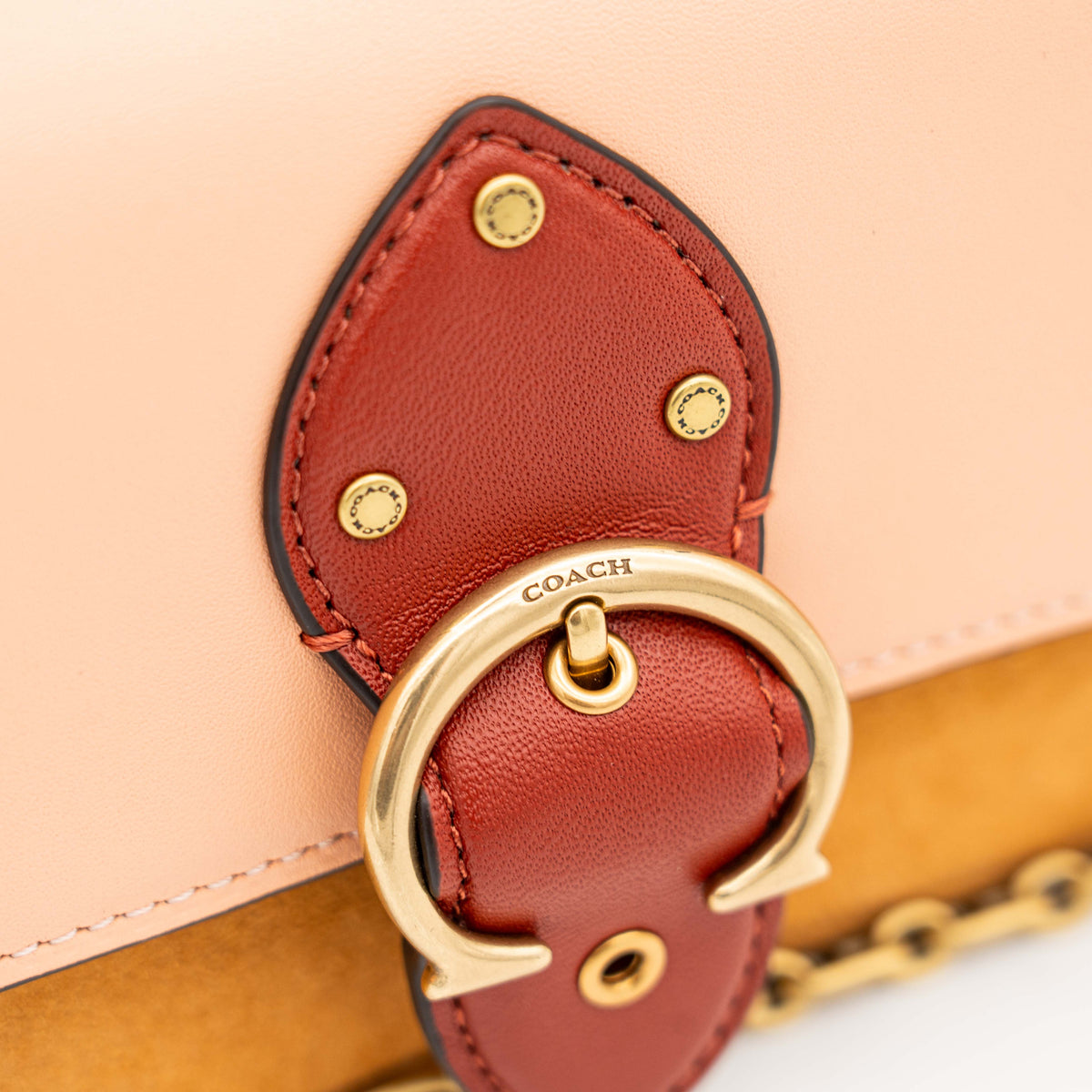 Coach Beat Crossbody Clutch 2Way in blush, tan, and red leather with brass hardware and detachable strap, displayed with chain handle.
