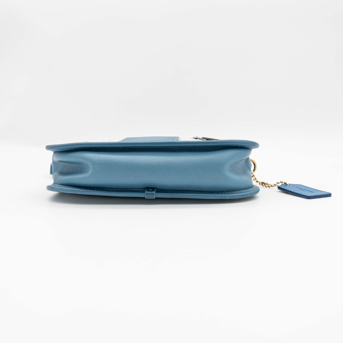 Coach 2Way Signature Swinger Shoulder Bag in light blue monogram canvas and leather with dinosaur and rainbow patches, shown with detachable strap.
