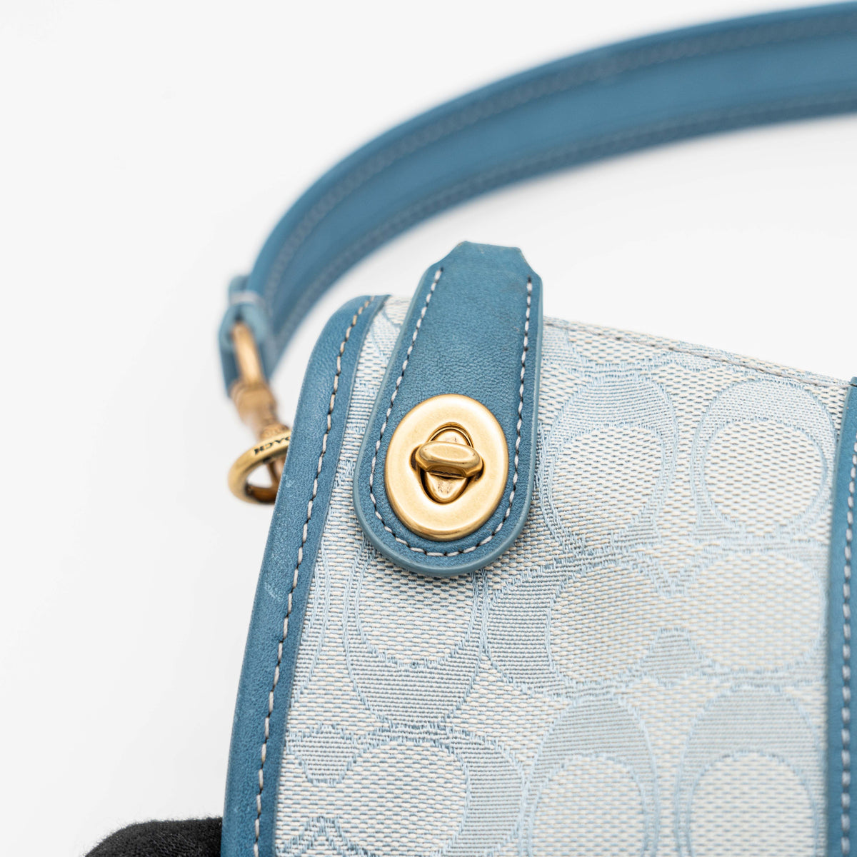 Coach 2Way Signature Swinger Shoulder Bag in light blue monogram canvas and leather with dinosaur and rainbow patches, shown with detachable strap.