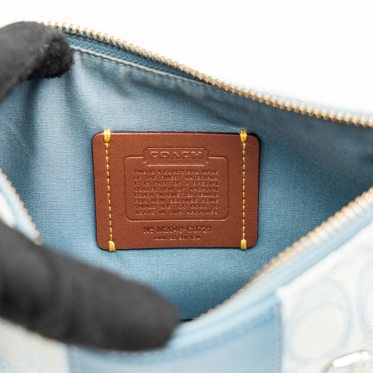 Coach 2Way Signature Swinger Shoulder Bag in light blue monogram canvas and leather with dinosaur and rainbow patches, shown with detachable strap.
