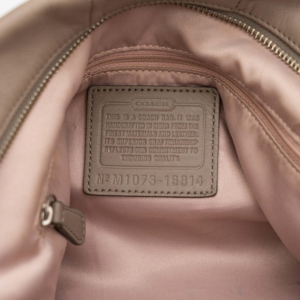Coach Kristin East West Shoulder Bag in beige leather with silver-tone hardware and double handles.