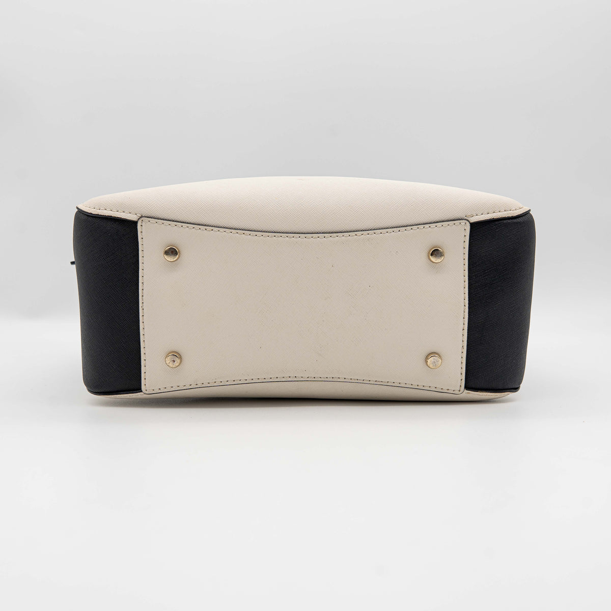 Kate Spade Cameron Street Little Babe satchel in black and white leather with gold hardware, shown with dual handles against a minimal background.