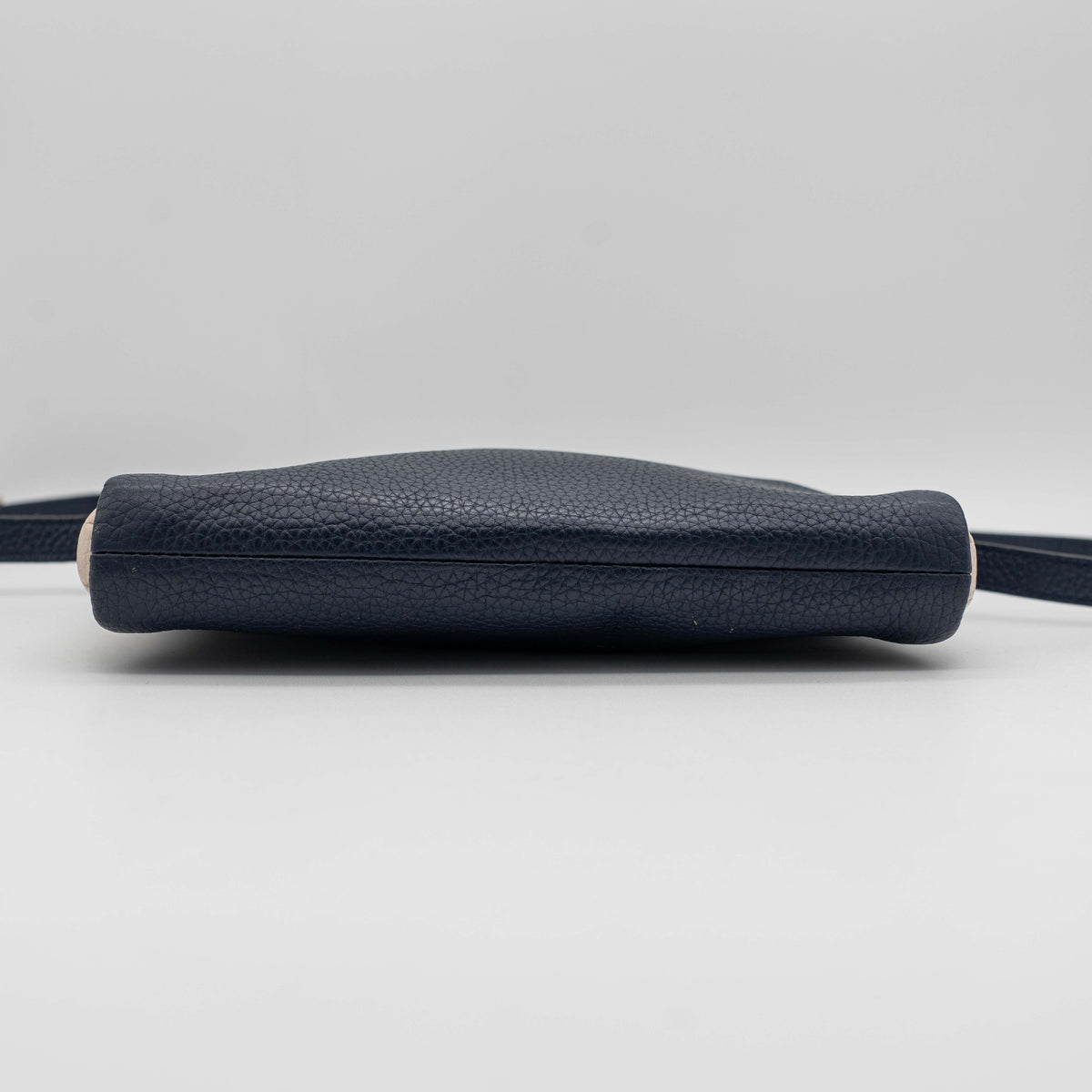 Kate Spade navy blue crossbody bag in pebbled leather, shown with adjustable strap and gold-tone accents.
