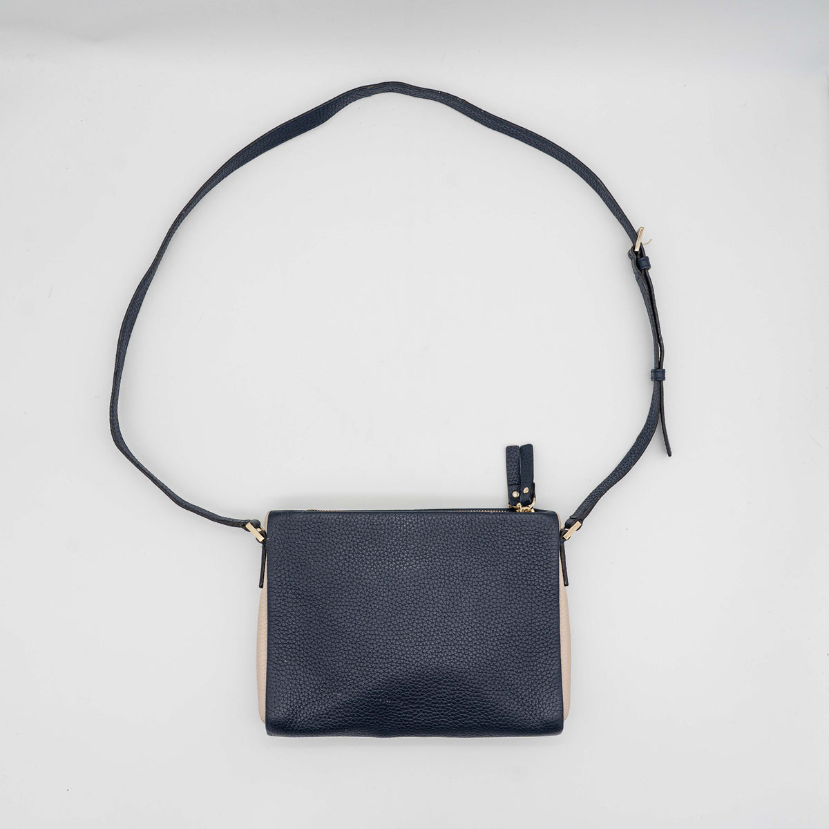 Kate Spade navy blue crossbody bag in pebbled leather, shown with adjustable strap and gold-tone accents.