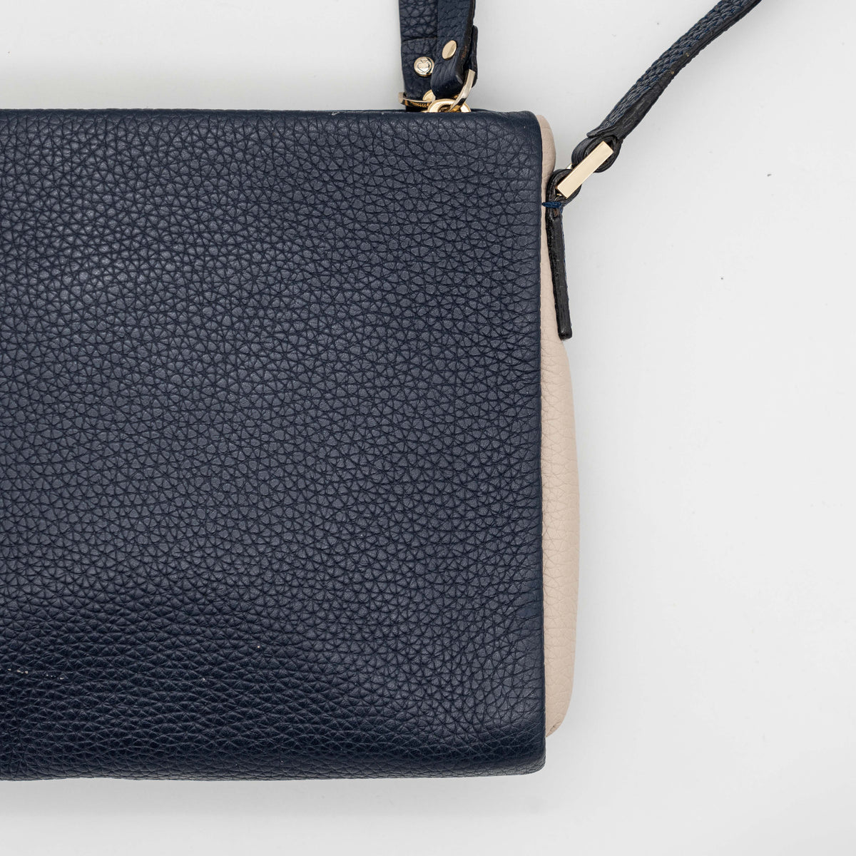 Kate Spade navy blue crossbody bag in pebbled leather, shown with adjustable strap and gold-tone accents.