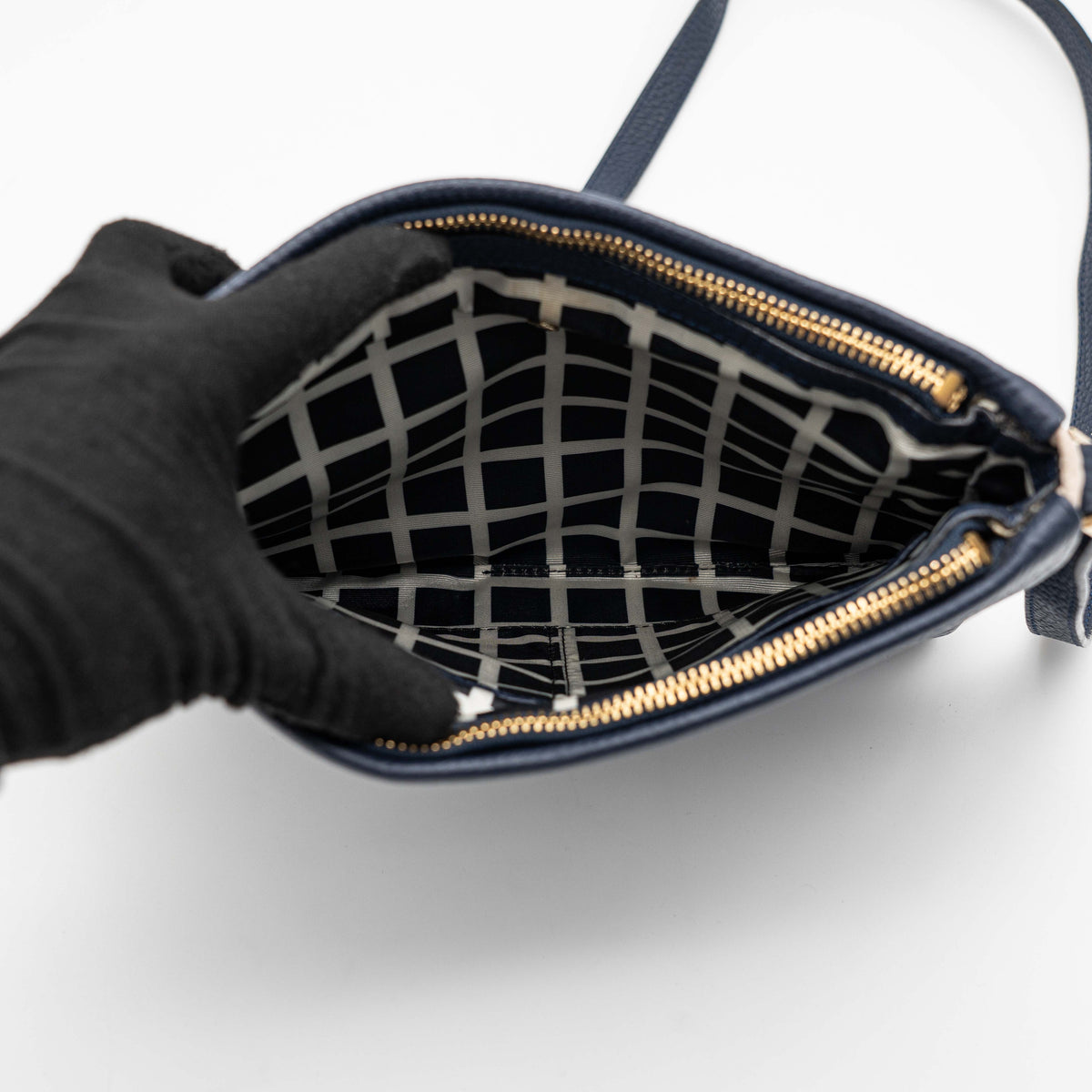 Kate Spade navy blue crossbody bag in pebbled leather, shown with adjustable strap and gold-tone accents.