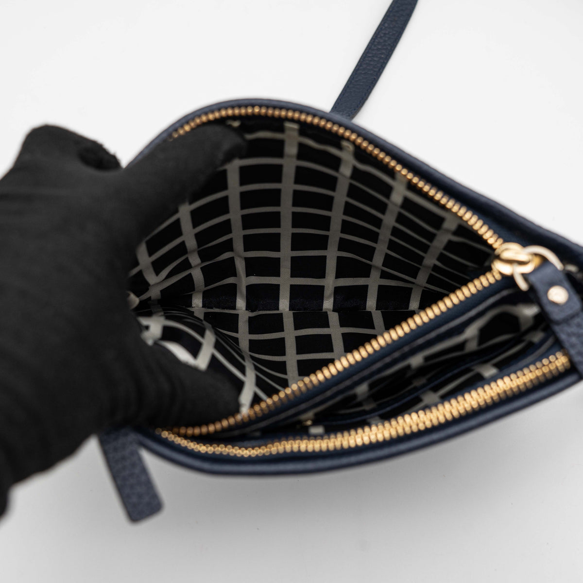 Kate Spade navy blue crossbody bag in pebbled leather, shown with adjustable strap and gold-tone accents.