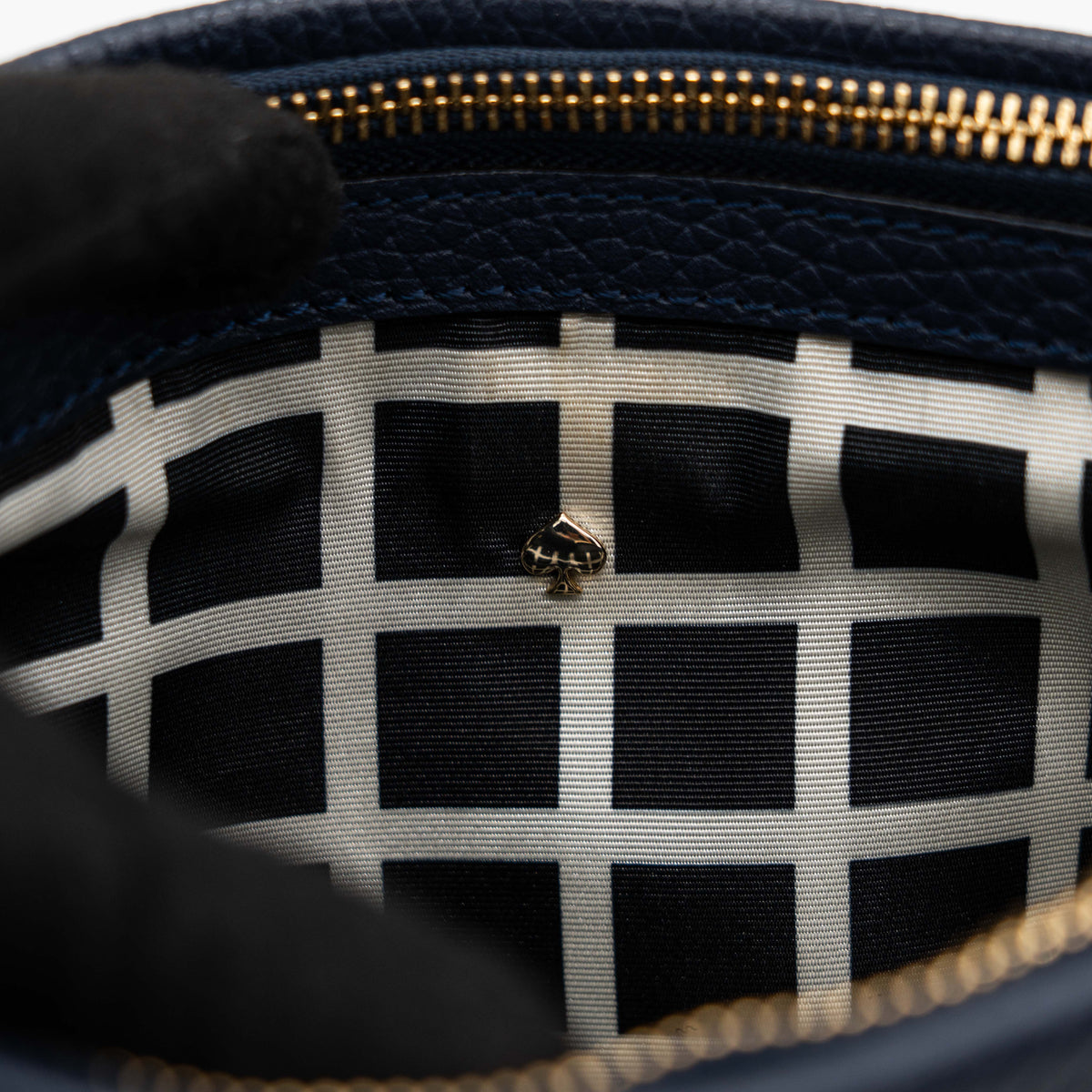 Kate Spade navy blue crossbody bag in pebbled leather, shown with adjustable strap and gold-tone accents.