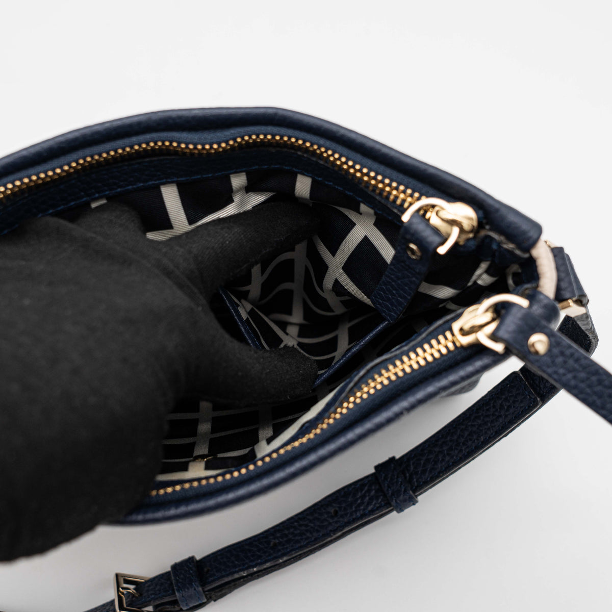 Kate Spade navy blue crossbody bag in pebbled leather, shown with adjustable strap and gold-tone accents.