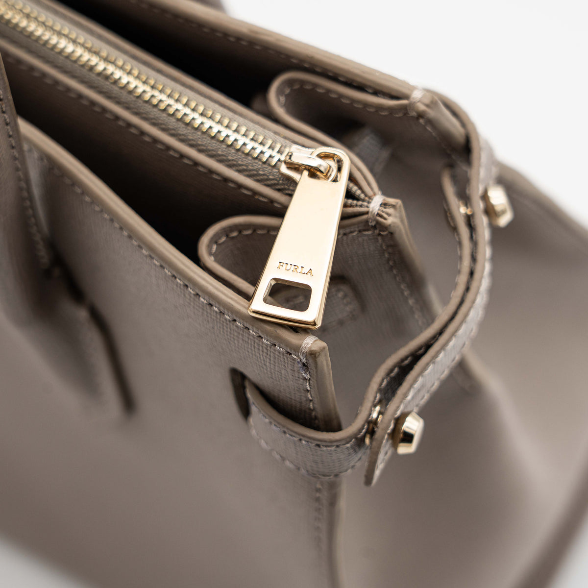 Furla grey Pin tote bag with top handles, gold hardware, and detachable strap against a white background.