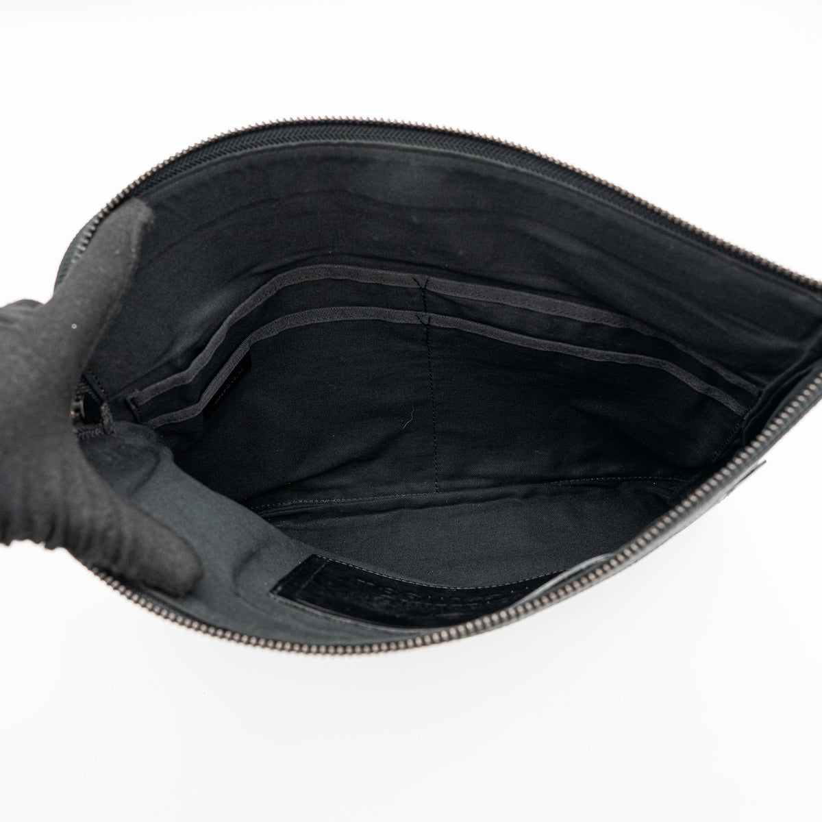 Vivienne Westwood clutch bag in grey and black graphic camouflage with matte black Orb logo and leather trim, styled against a white background.