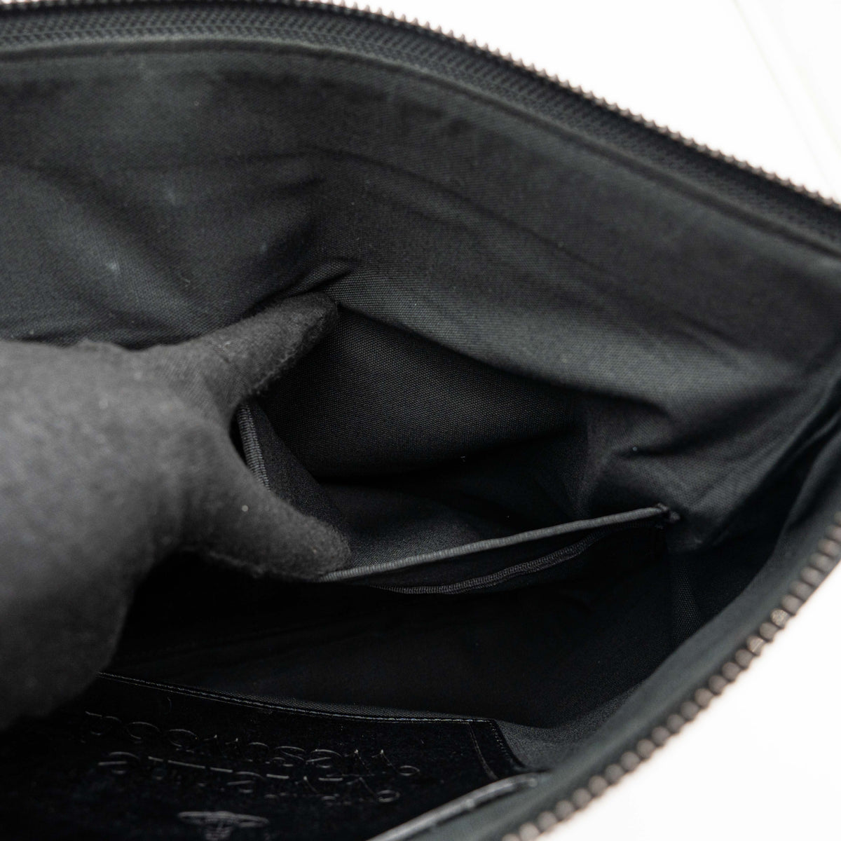 Vivienne Westwood clutch bag in grey and black graphic camouflage with matte black Orb logo and leather trim, styled against a white background.