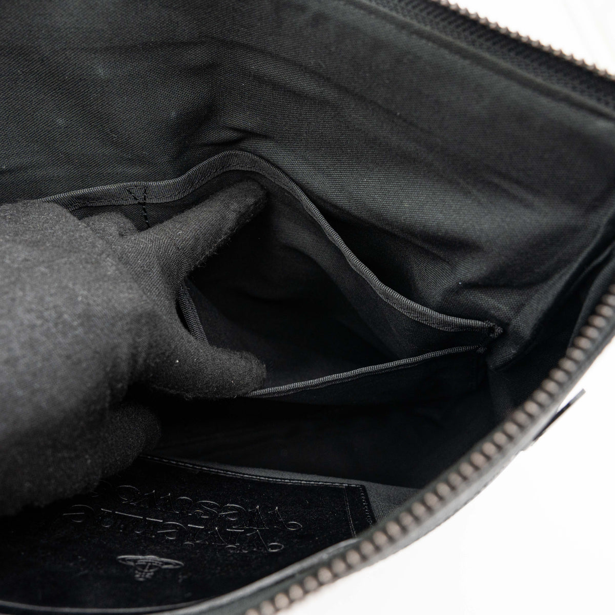Vivienne Westwood clutch bag in grey and black graphic camouflage with matte black Orb logo and leather trim, styled against a white background.