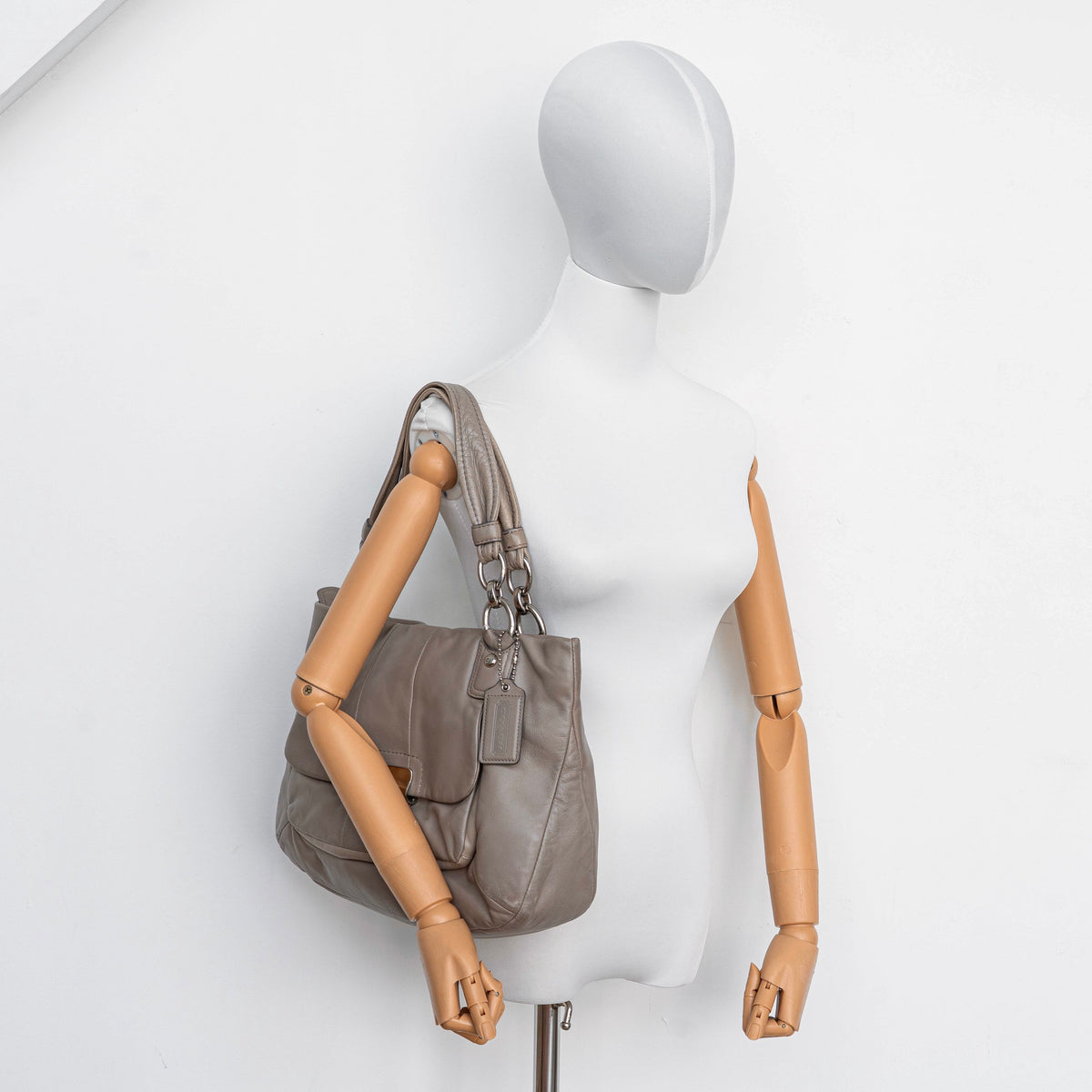 Coach Kristin East West Shoulder Bag in beige leather with silver-tone hardware and double handles.
