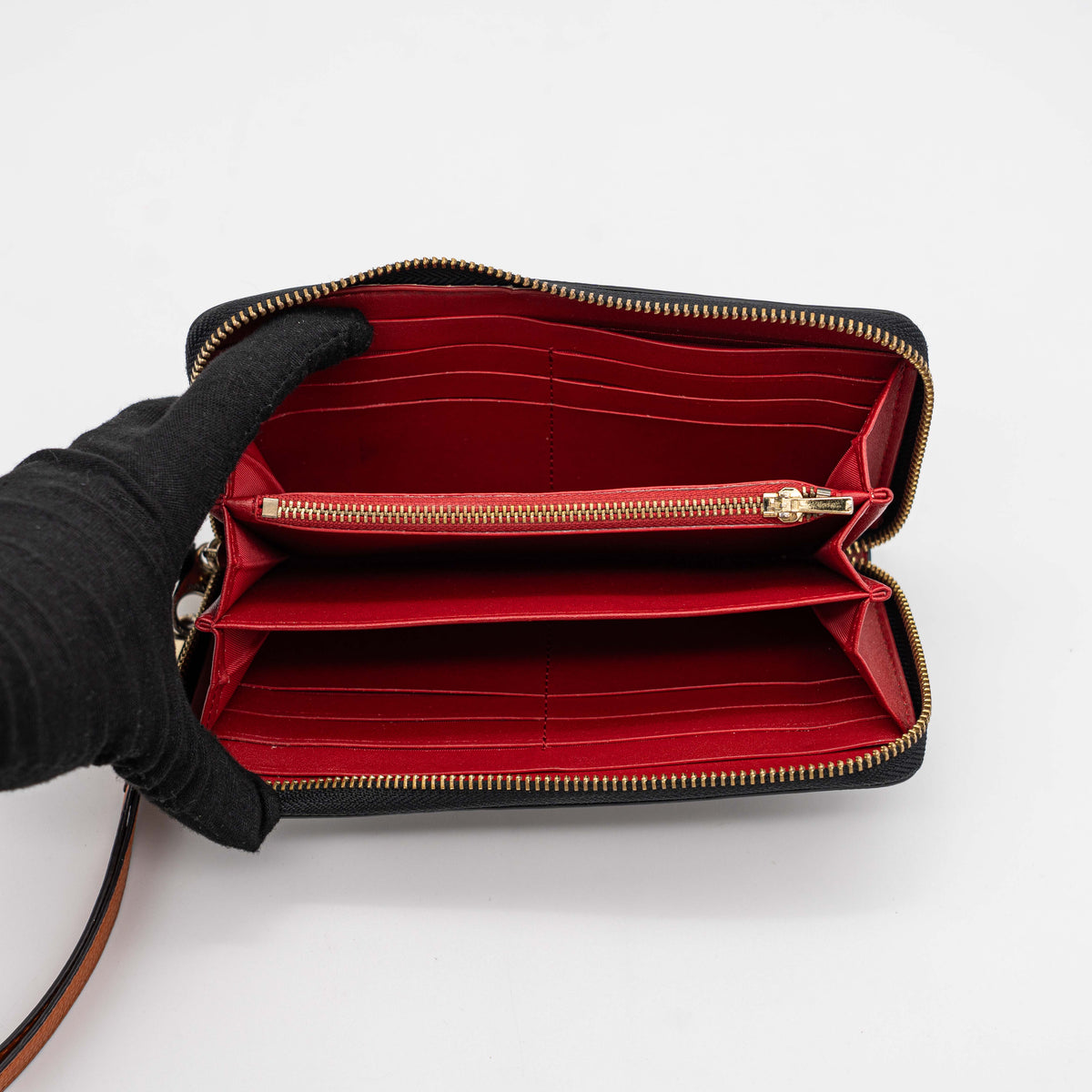 Coach Horse Carriage long zip around wallet in black pebbled leather with wristlet strap, featuring the embossed horse and carriage motif.